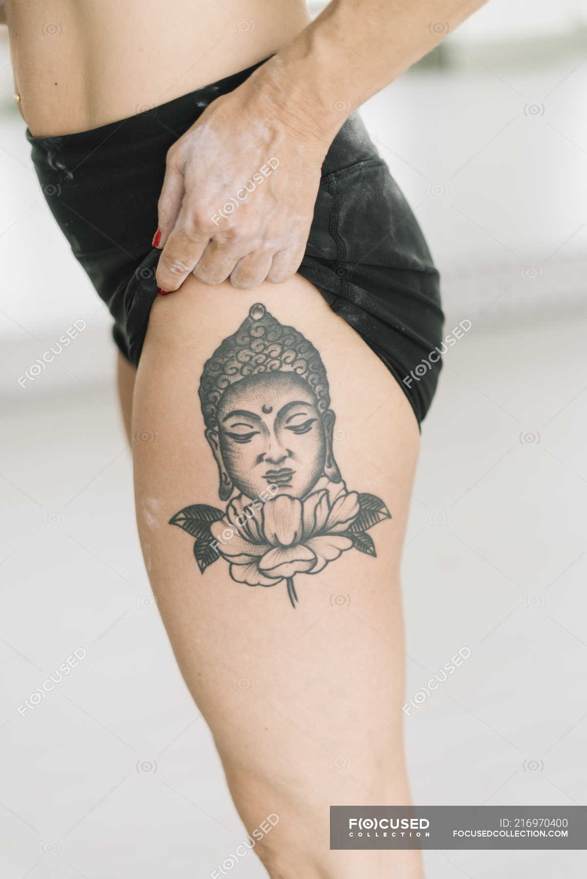 Close-up of female athlete showing Buddha tattoo on leg — muscular, woman -  Stock Photo | #216970400
