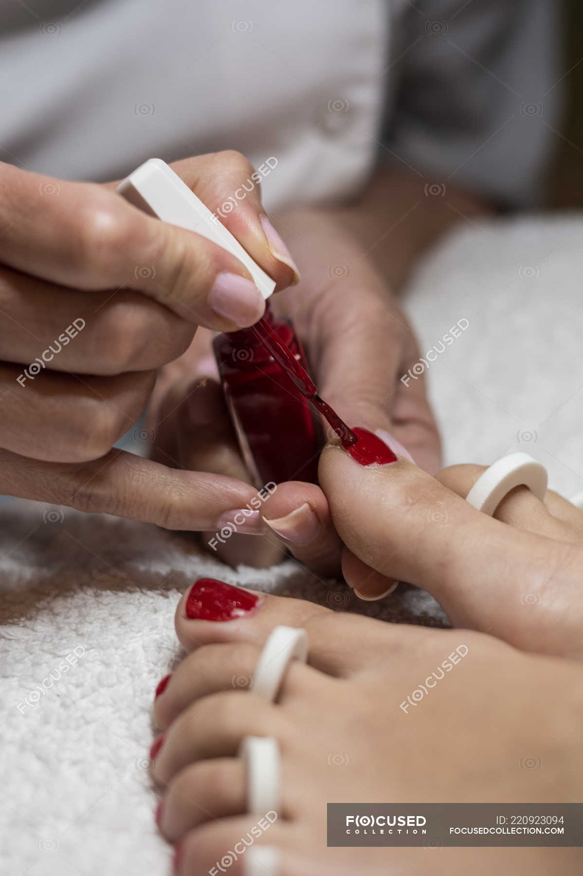 Female manicurist painting feet nails of client in beauty salon — close up,  wellness - Stock Photo | #220923094