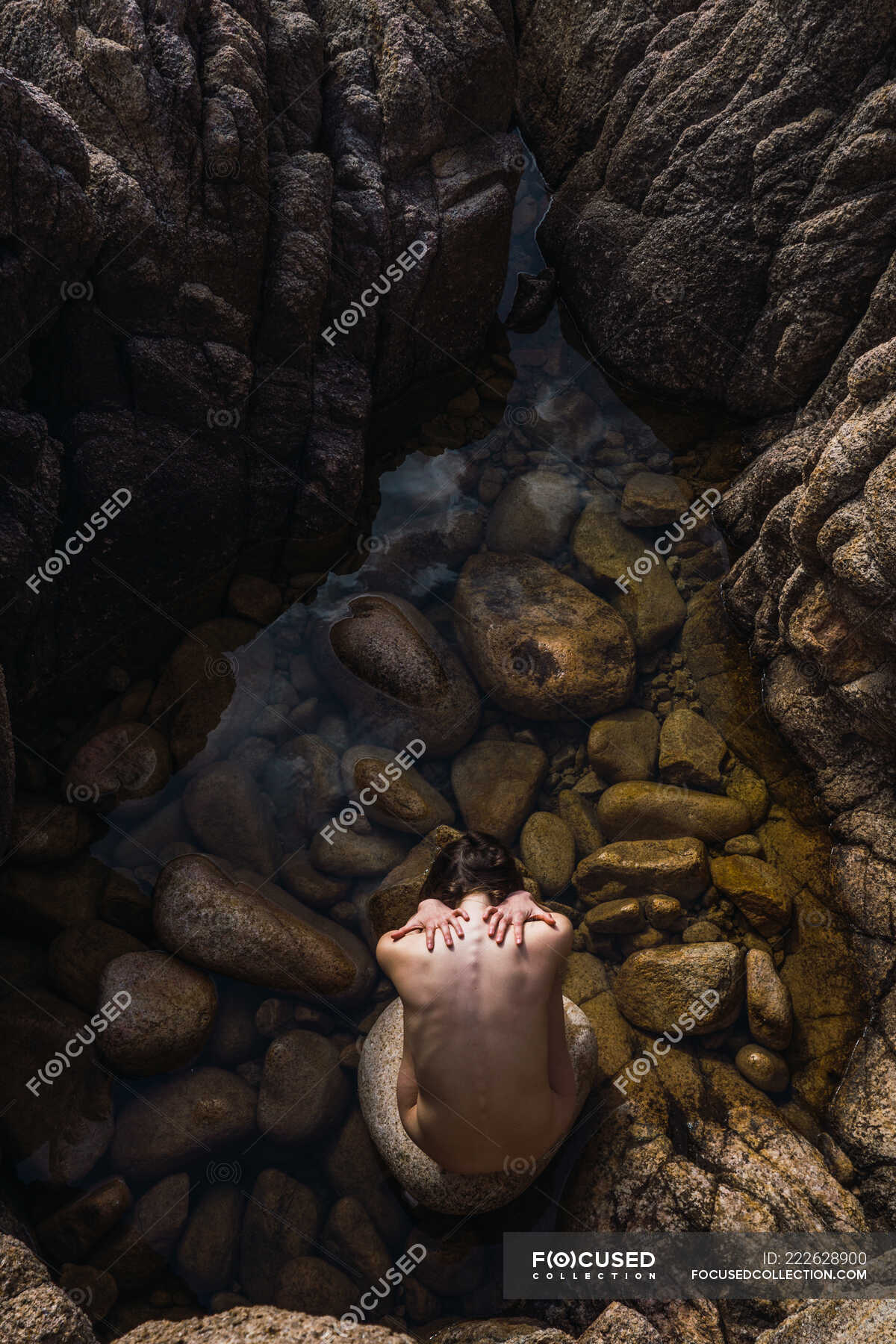 Top view of nude woman sitting on stones and touching back in the water in  nature. â€” model, charming - Stock Photo | #222628900