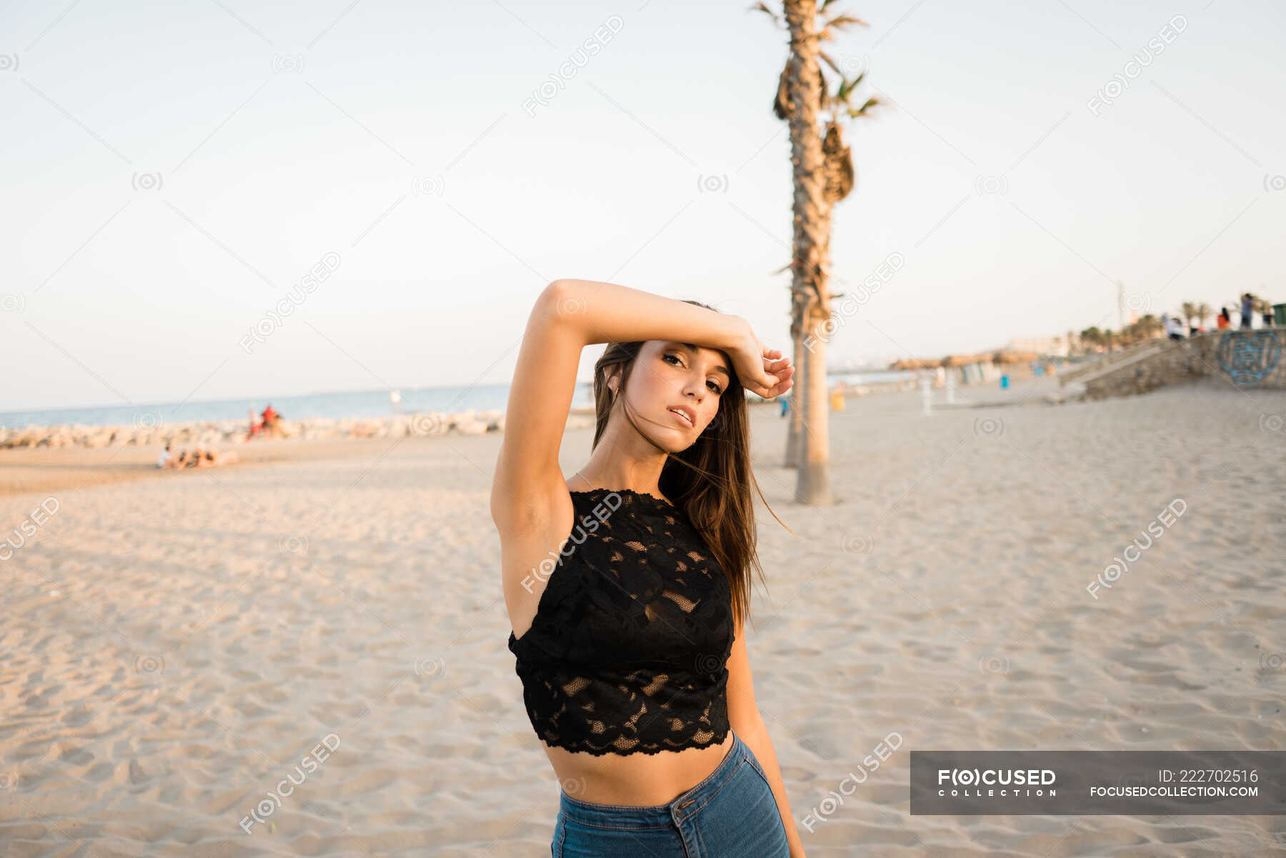 Young Woman on Black T-shirt, Fashion Sunglasses and Blue Jeans Stand on  the Beach, Looking at the Sea. Girl Doing Sunbath on Stock Image - Image of  resting, beauty: 185036683