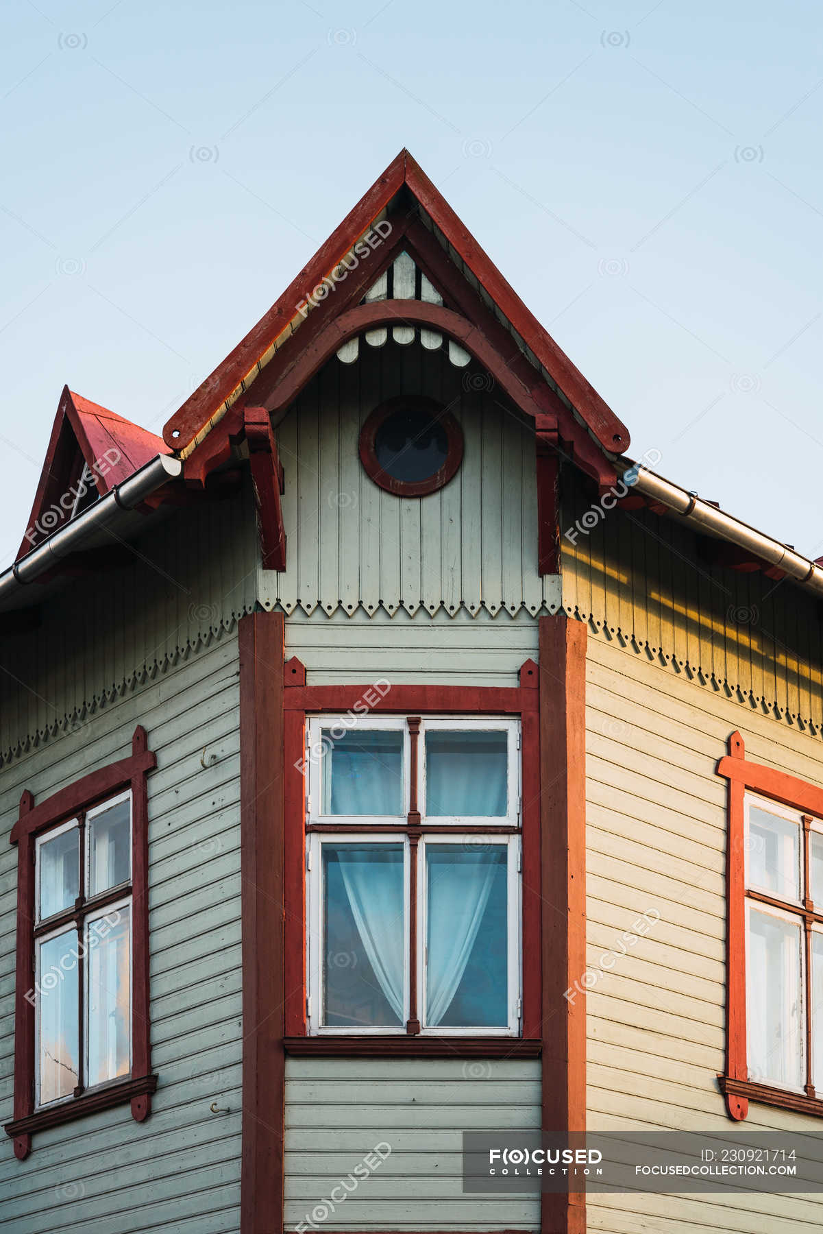 Windows under ornamental roof of old house on background of blue sky —  unusual, property - Stock Photo | #230921714