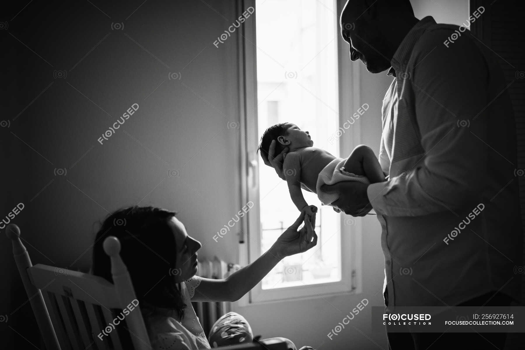 parents-holding-baby-in-room-together-family-stock-photo-256927614