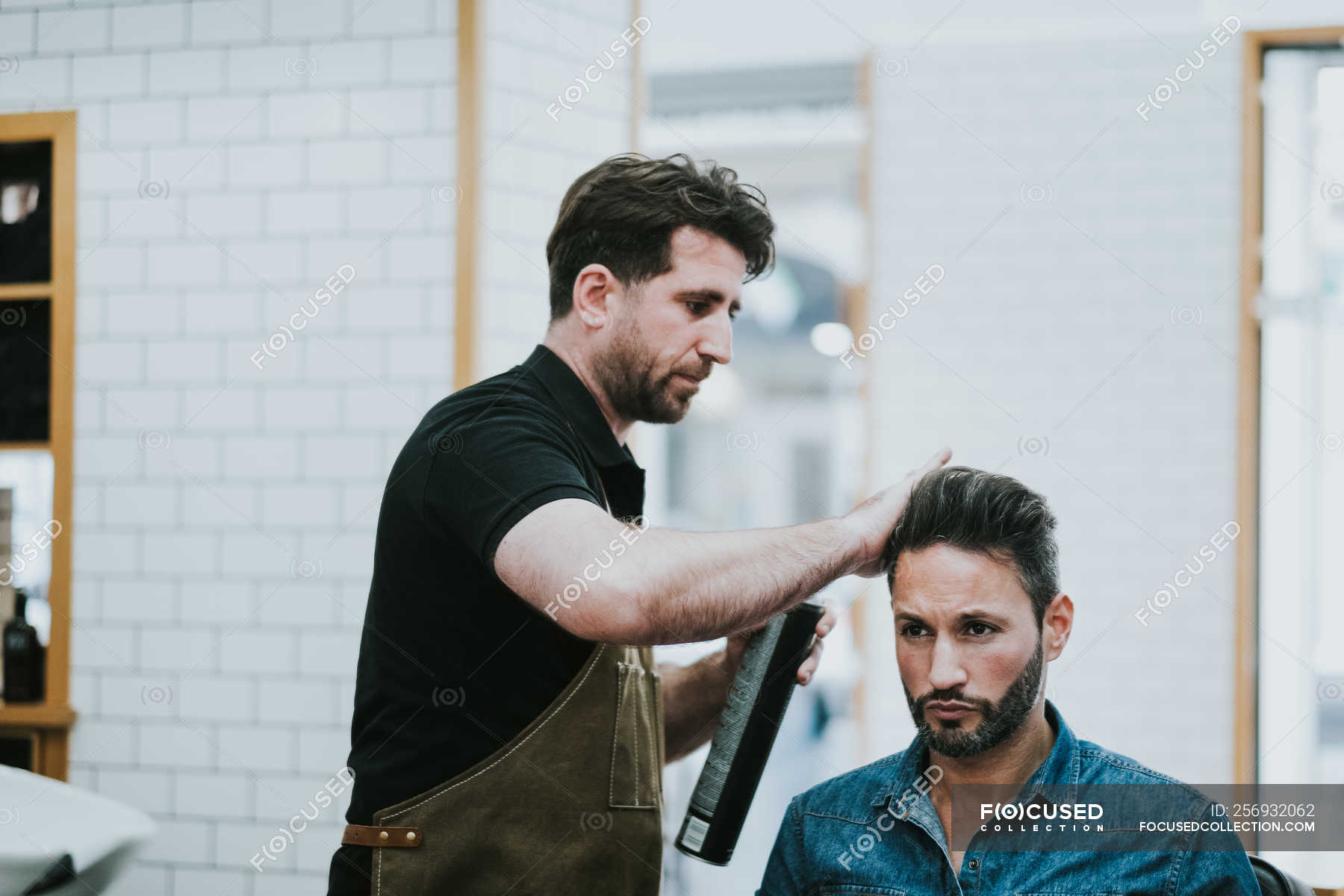 Barber applying hair gel on hair of handsome stylish male sitting in chair in barbershop — hairdo, professional - Stock Photo | #256932062 Barber applying hair gel on hair of handsome stylish male sitting in chair in barbershop — hairdo, professional - Stock Photo | #256932062