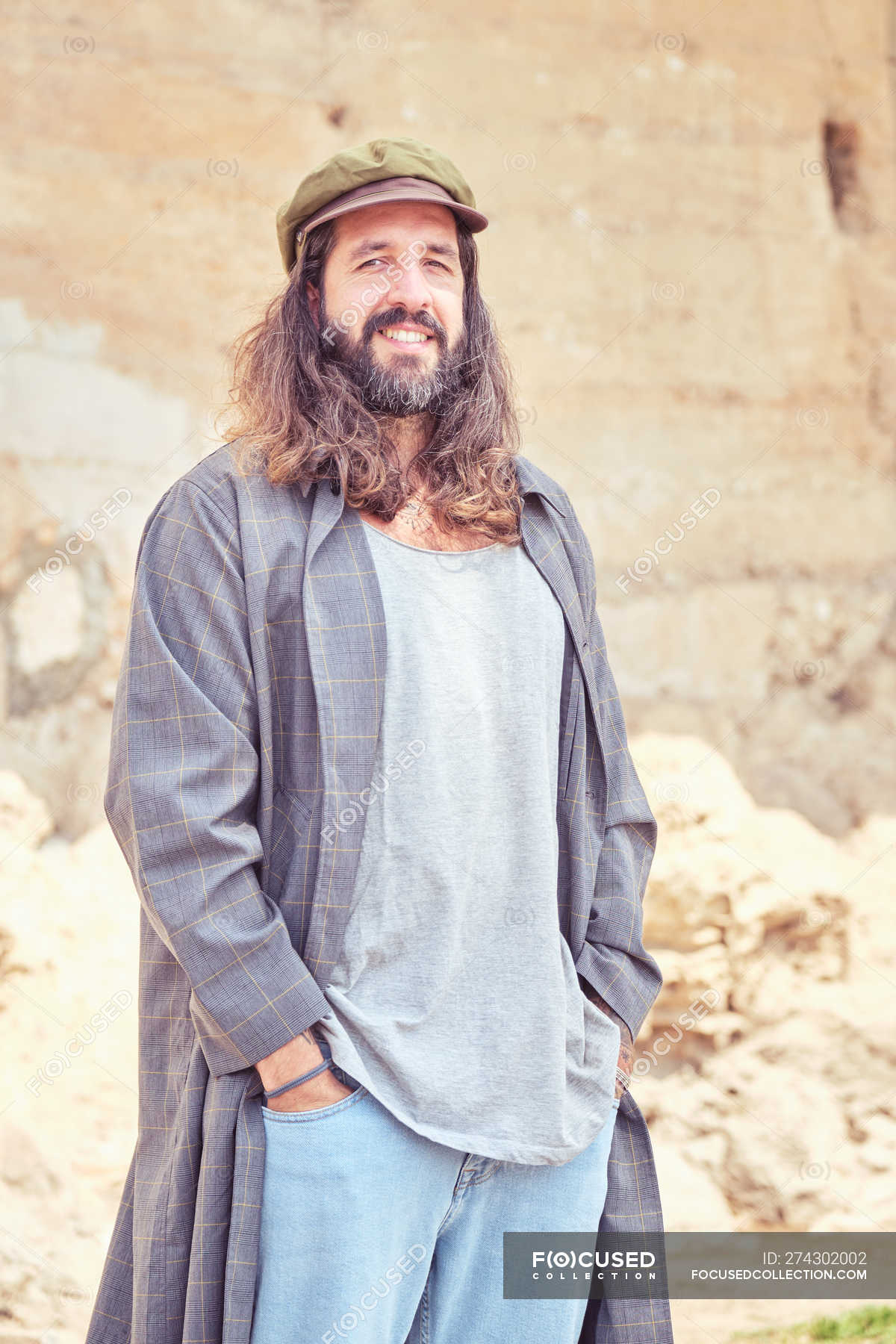 Stylish Bearded Man With Long Hair On Street Posing And Looking At