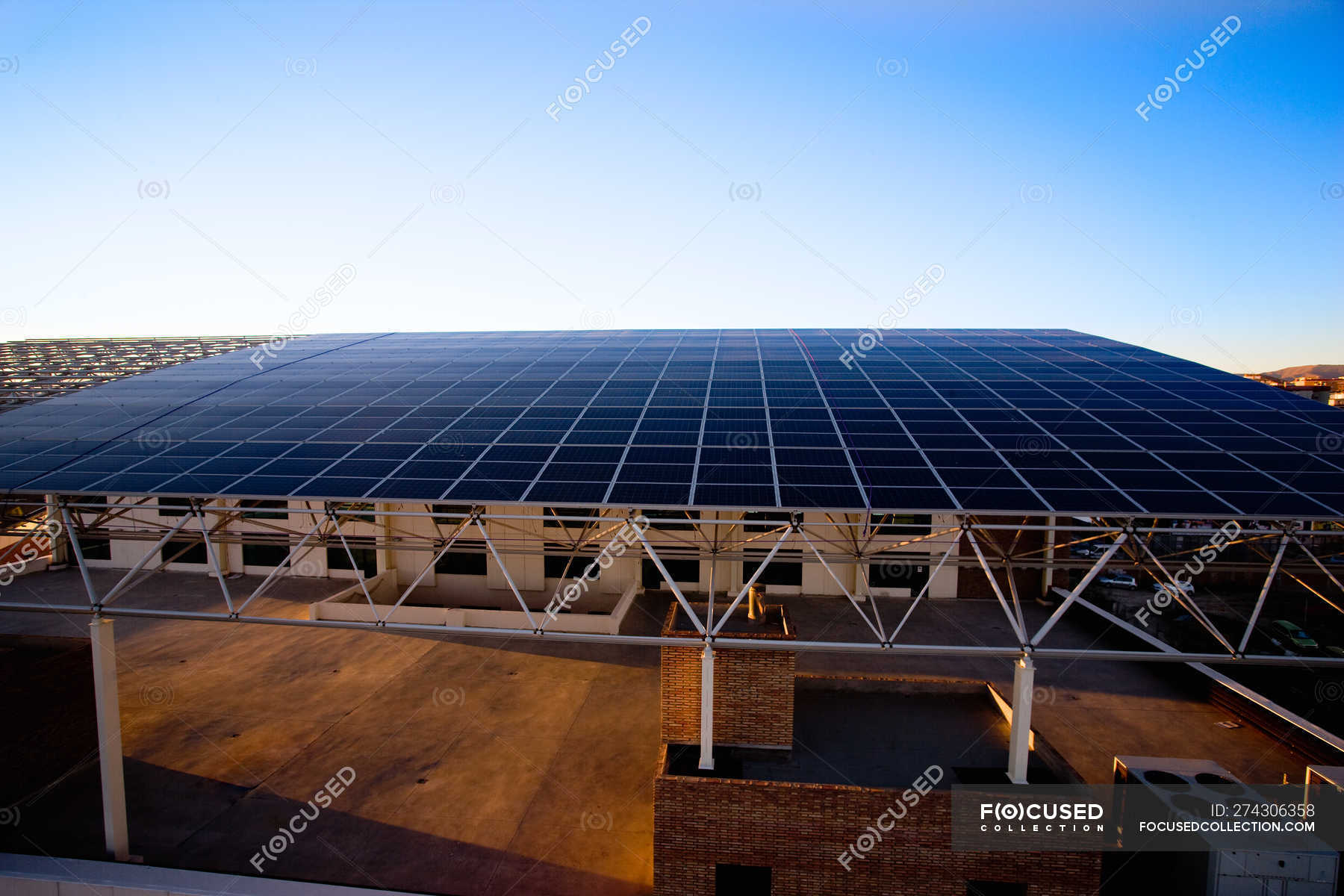 Building with roof made of solar panels under blue sky — urban, futuristic  - Stock Photo | #274306358