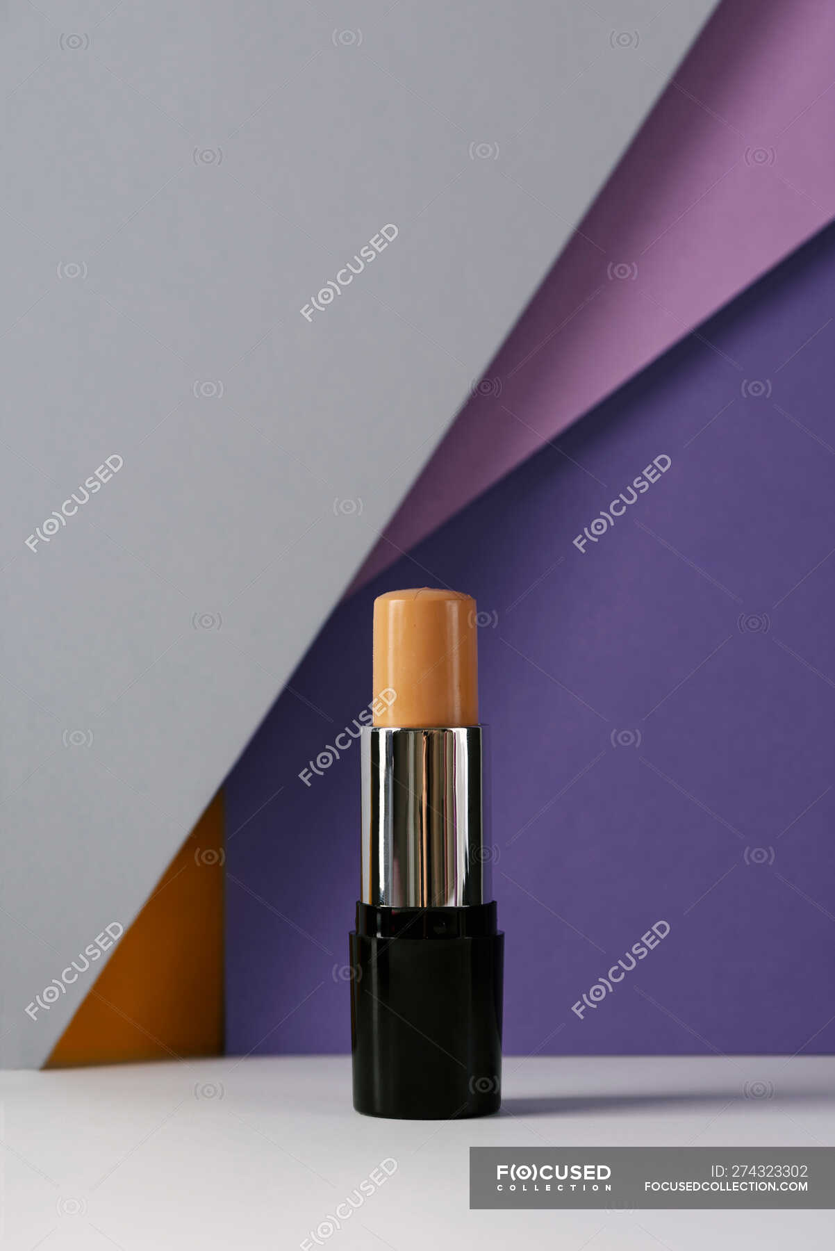 Concealer stick on modern background with geometric shapes. — light