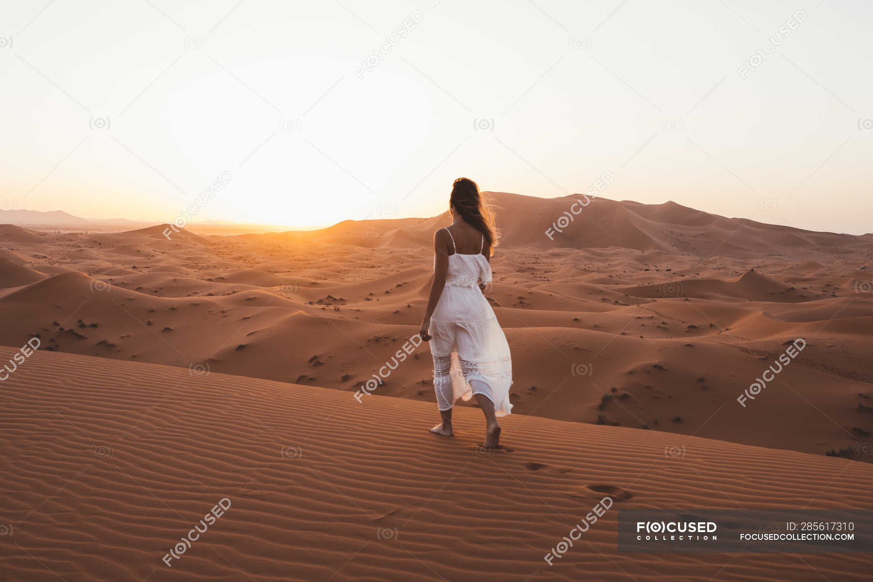 Vista Posteriore Della Donna A Piedi Nudi In Abito Bianco Estate Camminando Su Dune Sabbiose Di