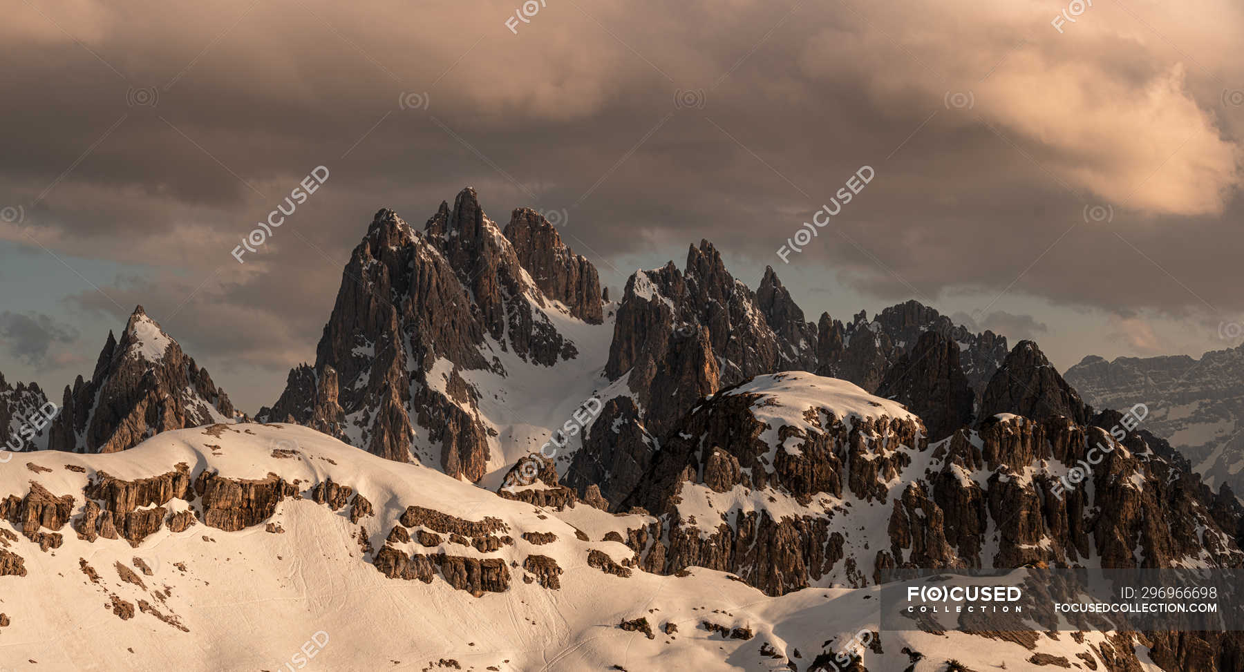 Majestic Landscape Of Snowy Rocky Peaks Under Heavy Dark Clouds In Gray Sky In Dolomites Italy Serenity Remote Stock Photo