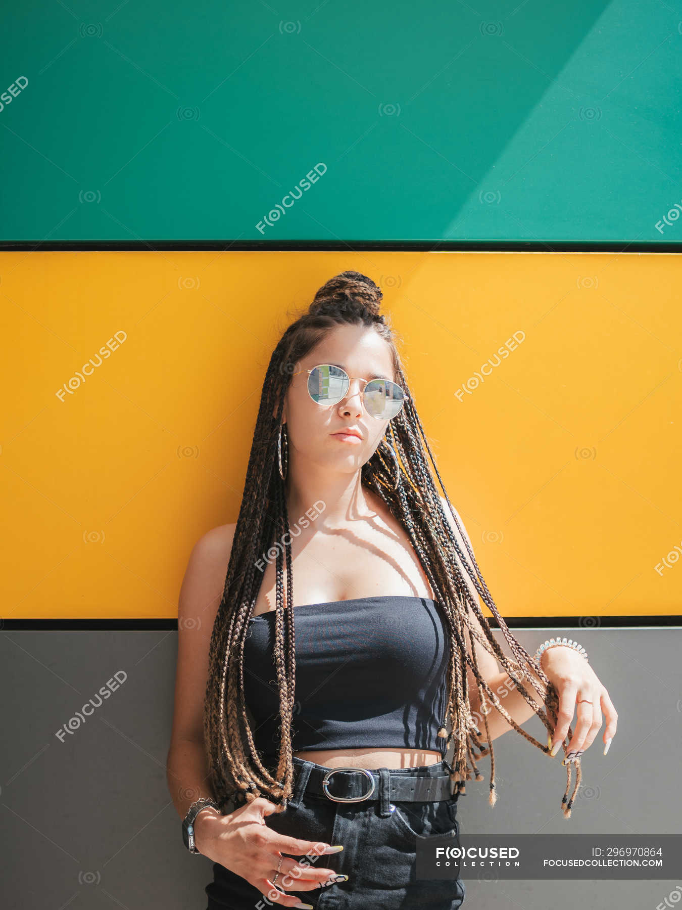 Pretty stylish teenage girl with unique dreadlocks looking at camera on ...