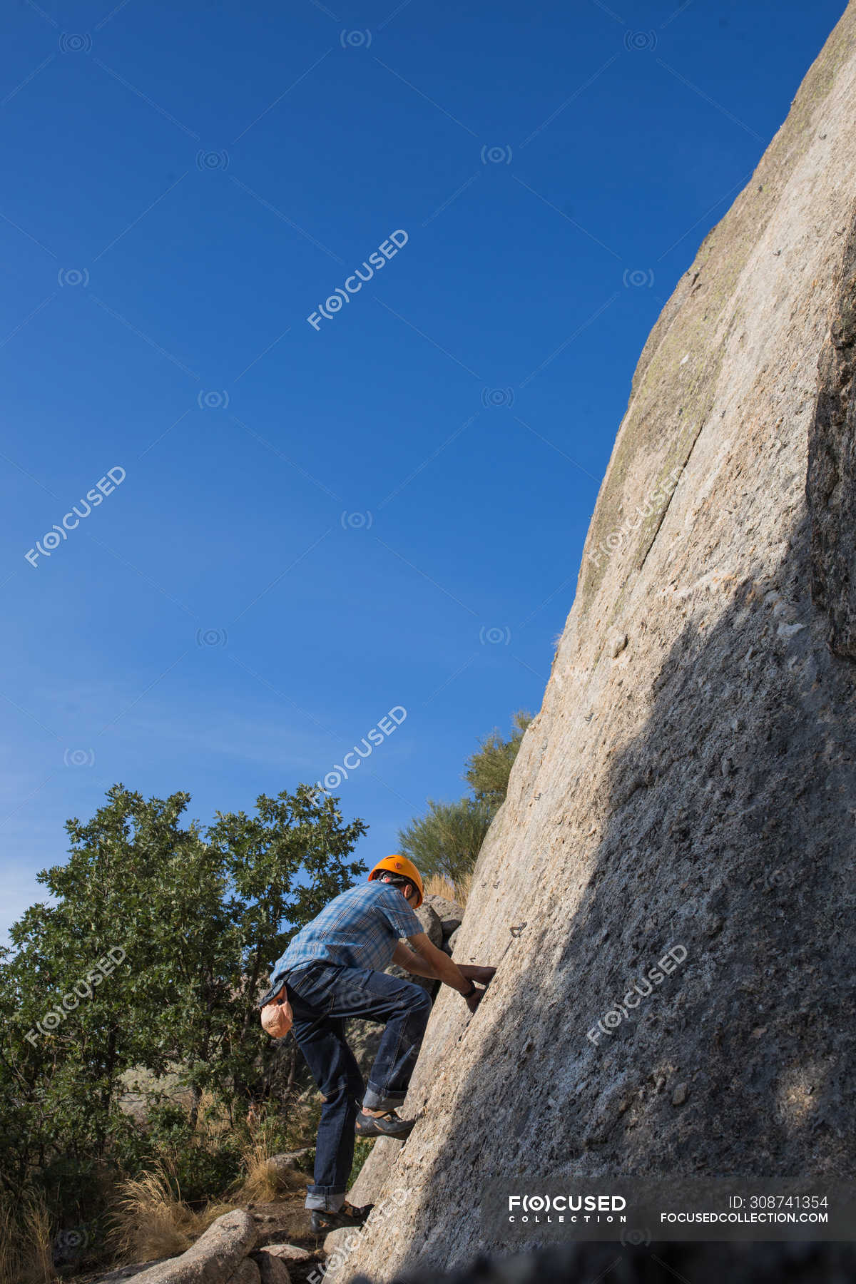 from-below-of-free-climber-climbing-in-nature-strong-rocks-stock