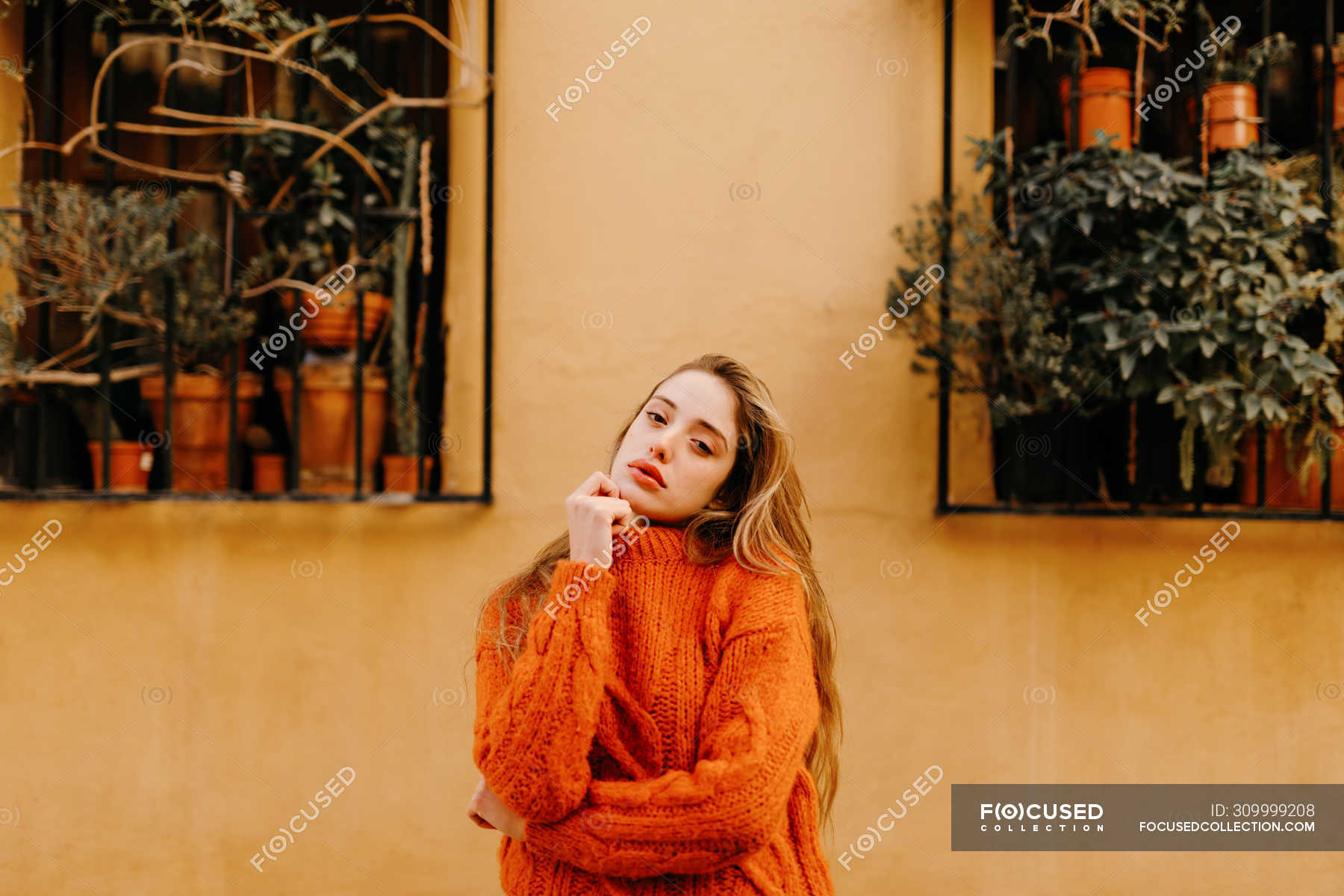 Sensual Girl In Trendy Knitted Sweater Touching Chin And Looking In