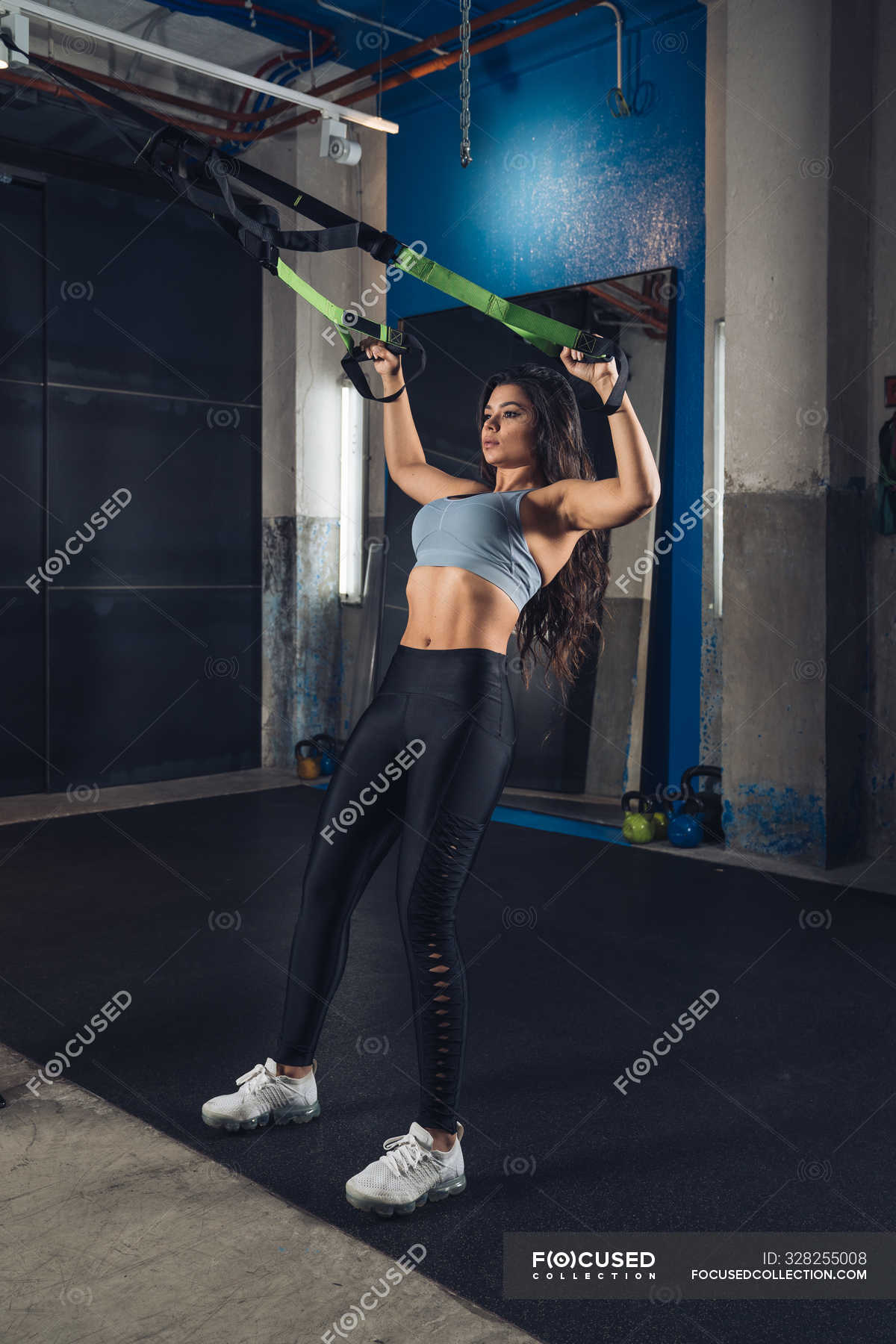 Woman pulling ropes and working out in the gym — fitness, gymnastics