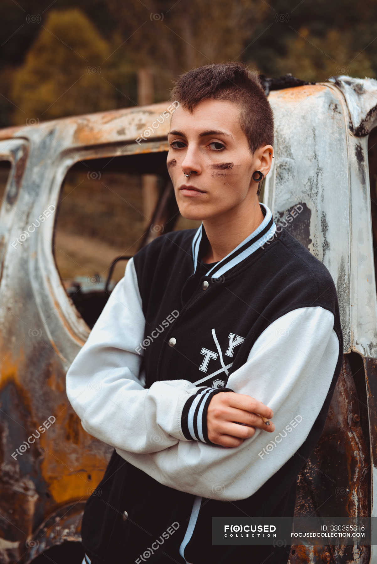 Stylish Tomboy With Short Hair And Painted Face Smoking Cigarette As Leaning On Old Rusty Car In Countryside Subculture Casual Stock Photo 330355816