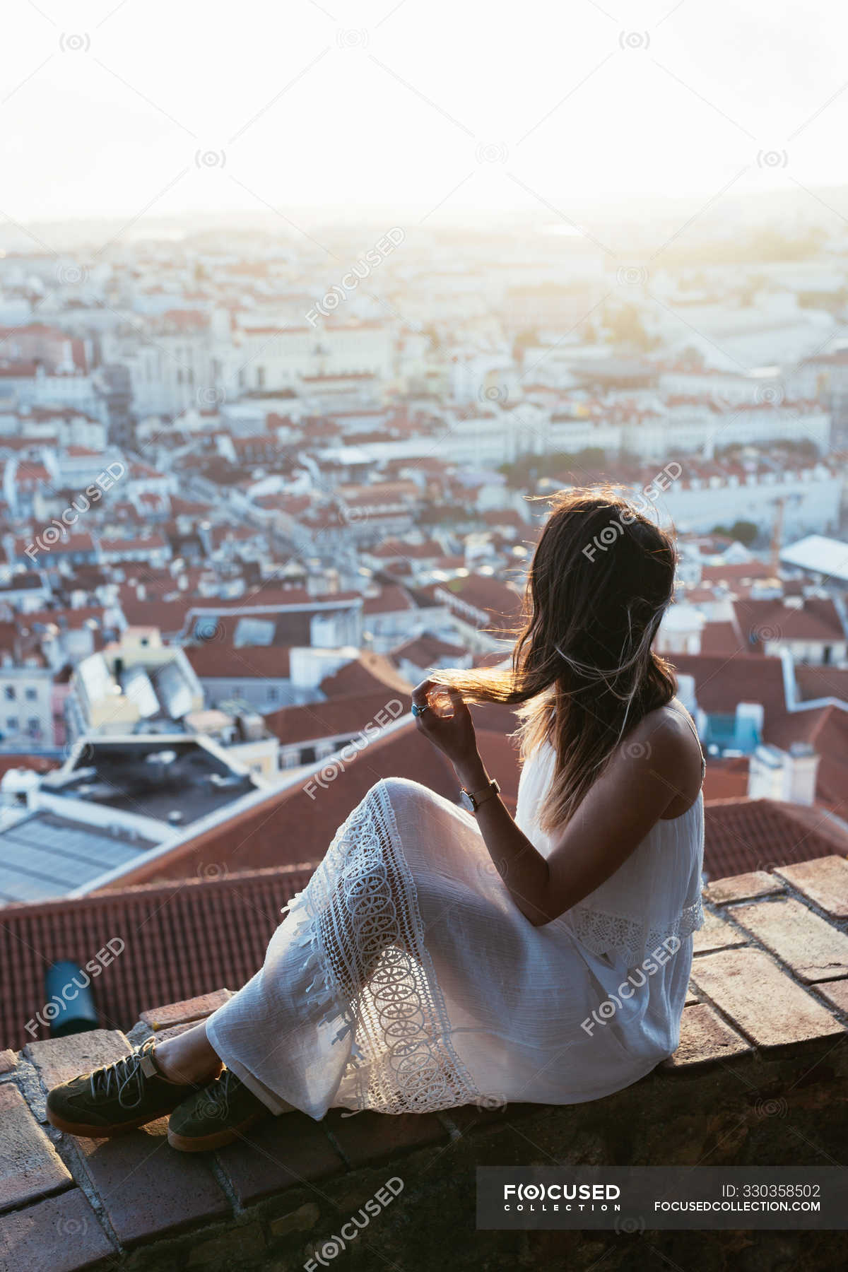 Dreamy woman sitting on border near city — dawn, vertical - Stock Photo ...