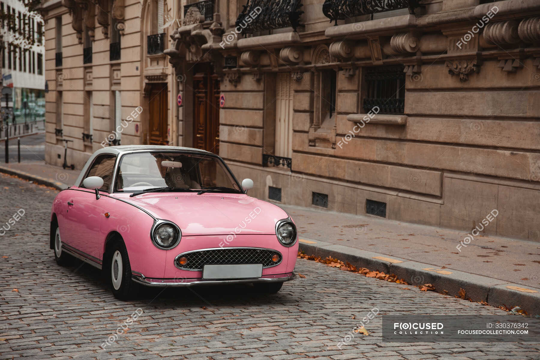 pink-retro-car-parked-on-old-town-street-in-paris-france-on-gloomy