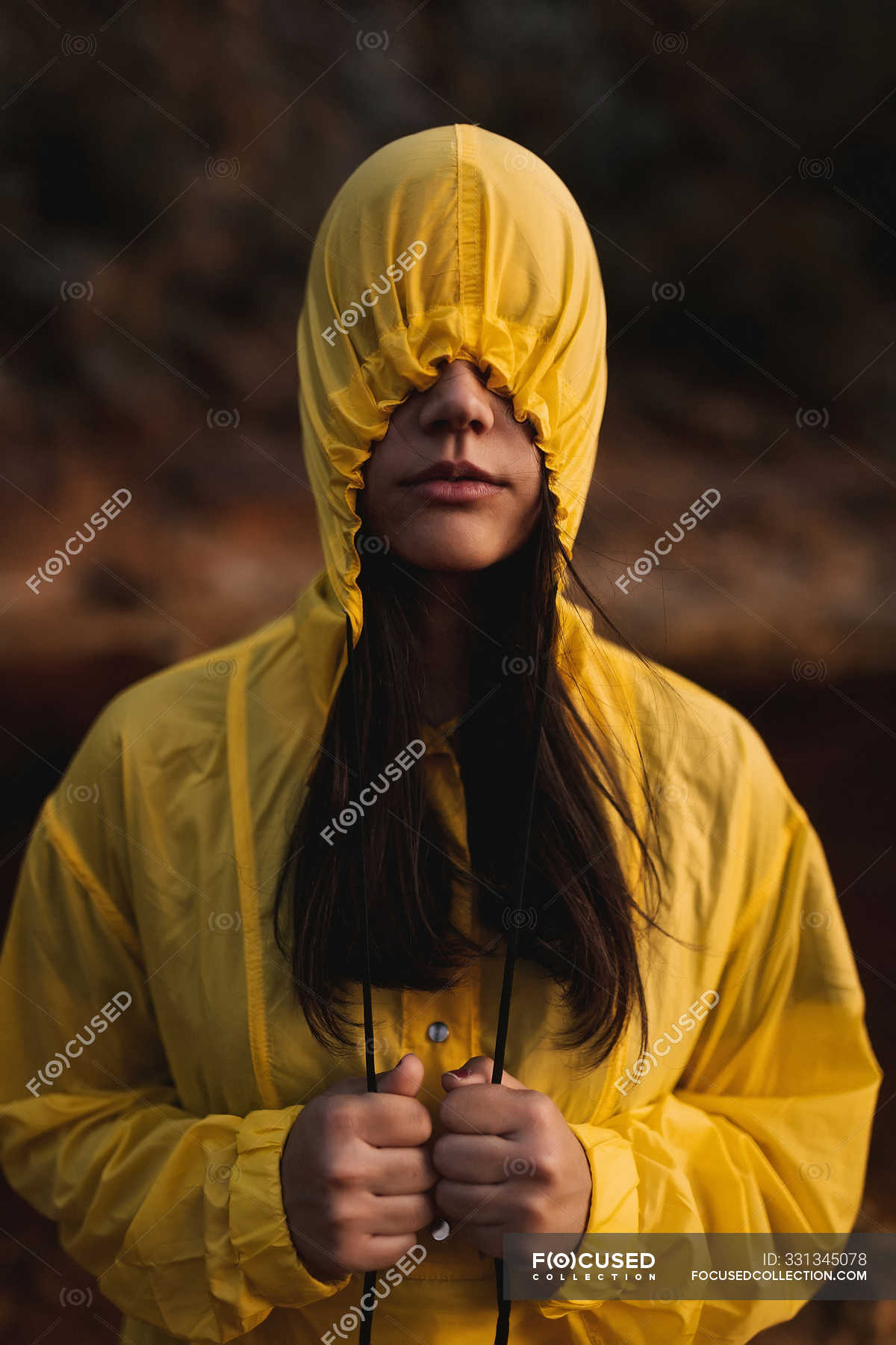 Woman In Yellow Rain Coat Wearing Hood Covering Face Standing In Nature On Cloudy Day Cover Face Brunette Stock Photo 331345078