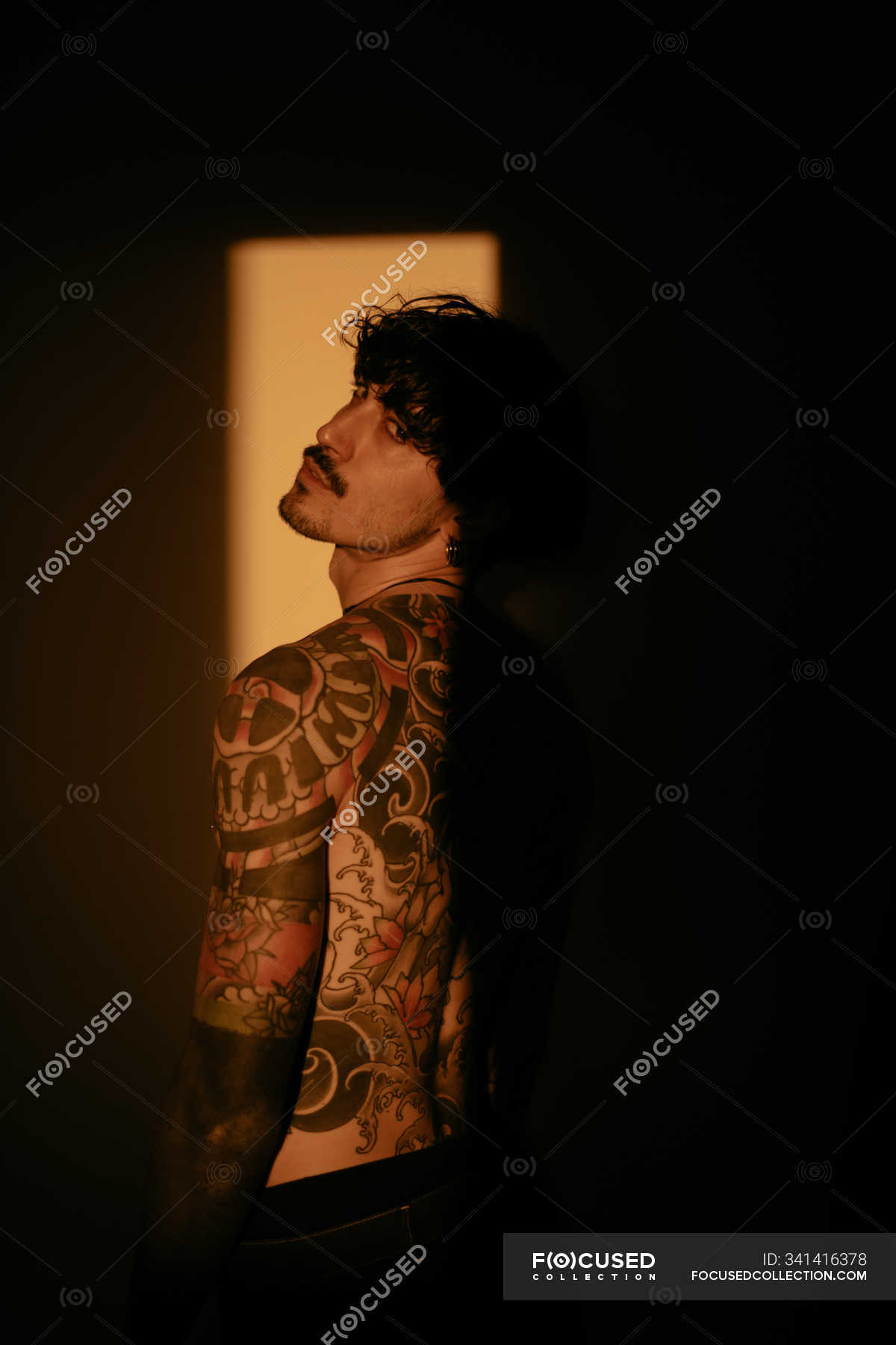 Handsome shirtless tattooed man posing sensually in sunlight — caucasian ethnicity, stylish - Stock Photo