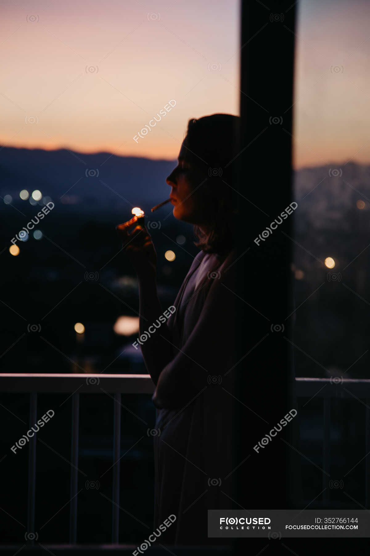 Side View Of Young Faceless Woman Lighting Cigarette With Magnificent Sunset On Blurred Background Dream Person Stock Photo