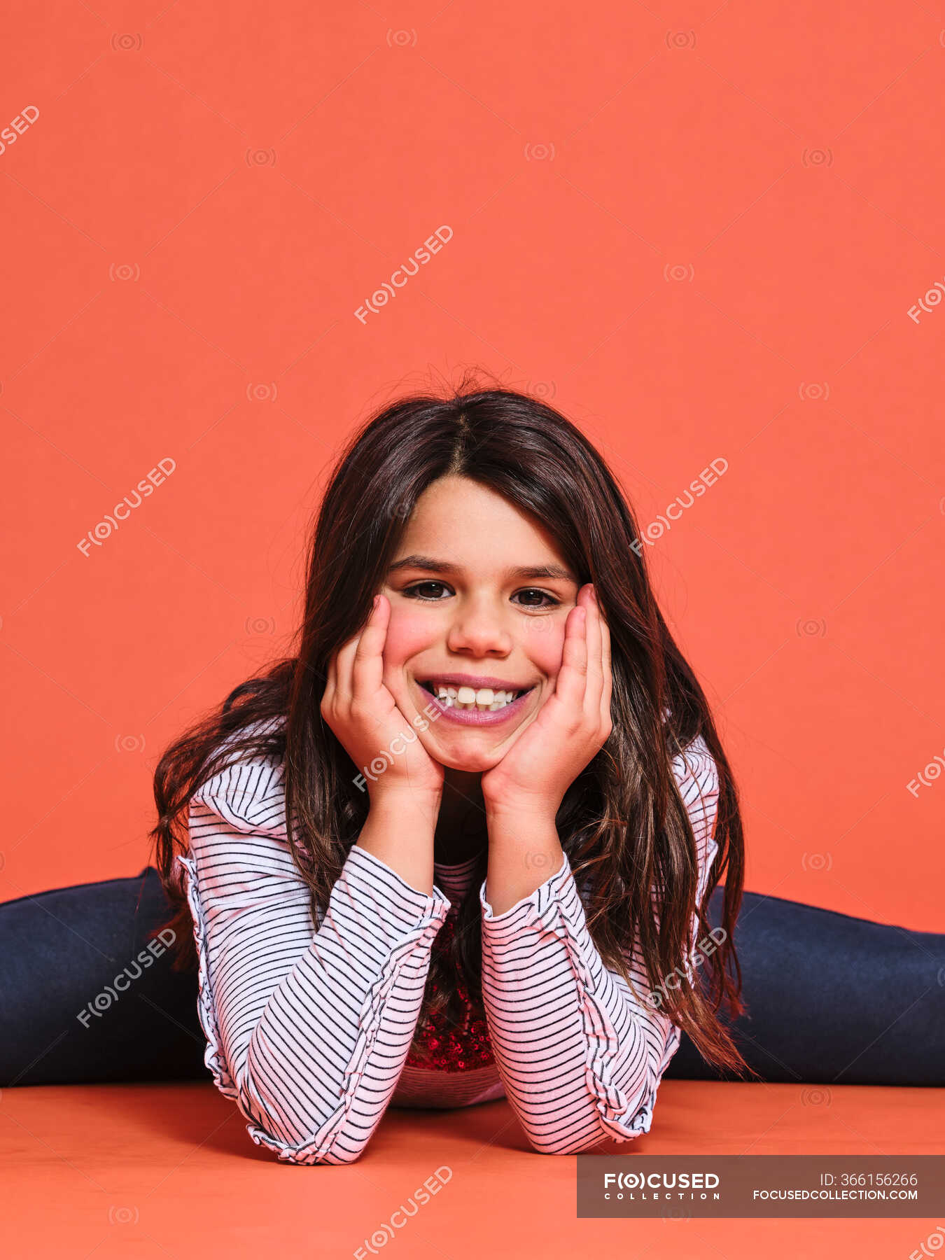 Happy Preteen Girl Gymnast In Trendy Clothes Looking At Camera While Sitting With Leg Stretched 