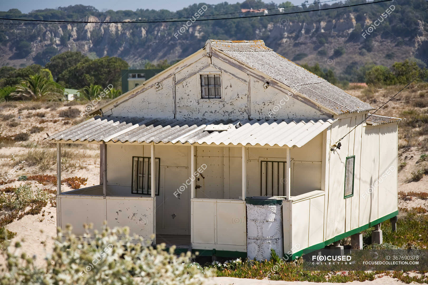 Exterior of small residential house with shabby white walls built on ...