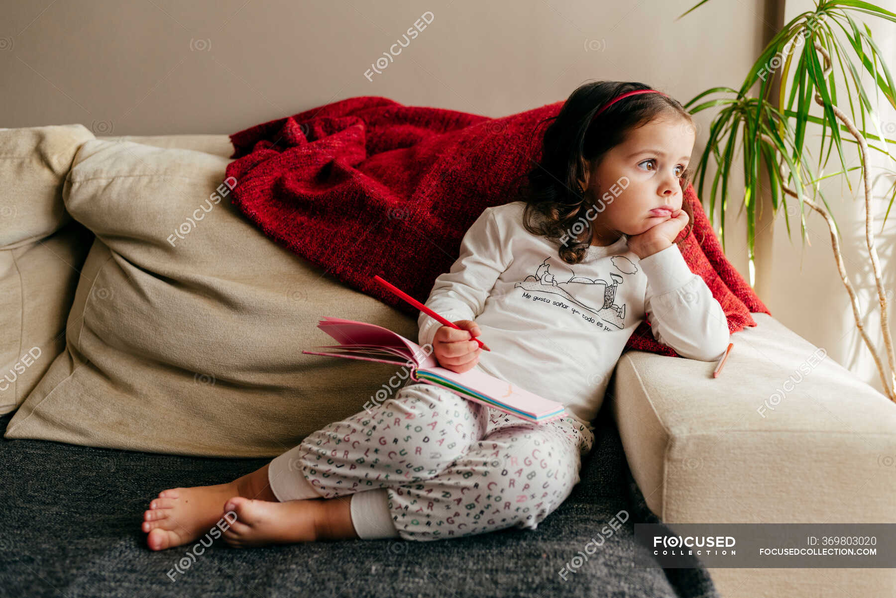 Nettes Kleines Mädchen Sitzt Auf Der Couch Mit Einem Notizbuch Auf Der Suche Nach Inspiration 