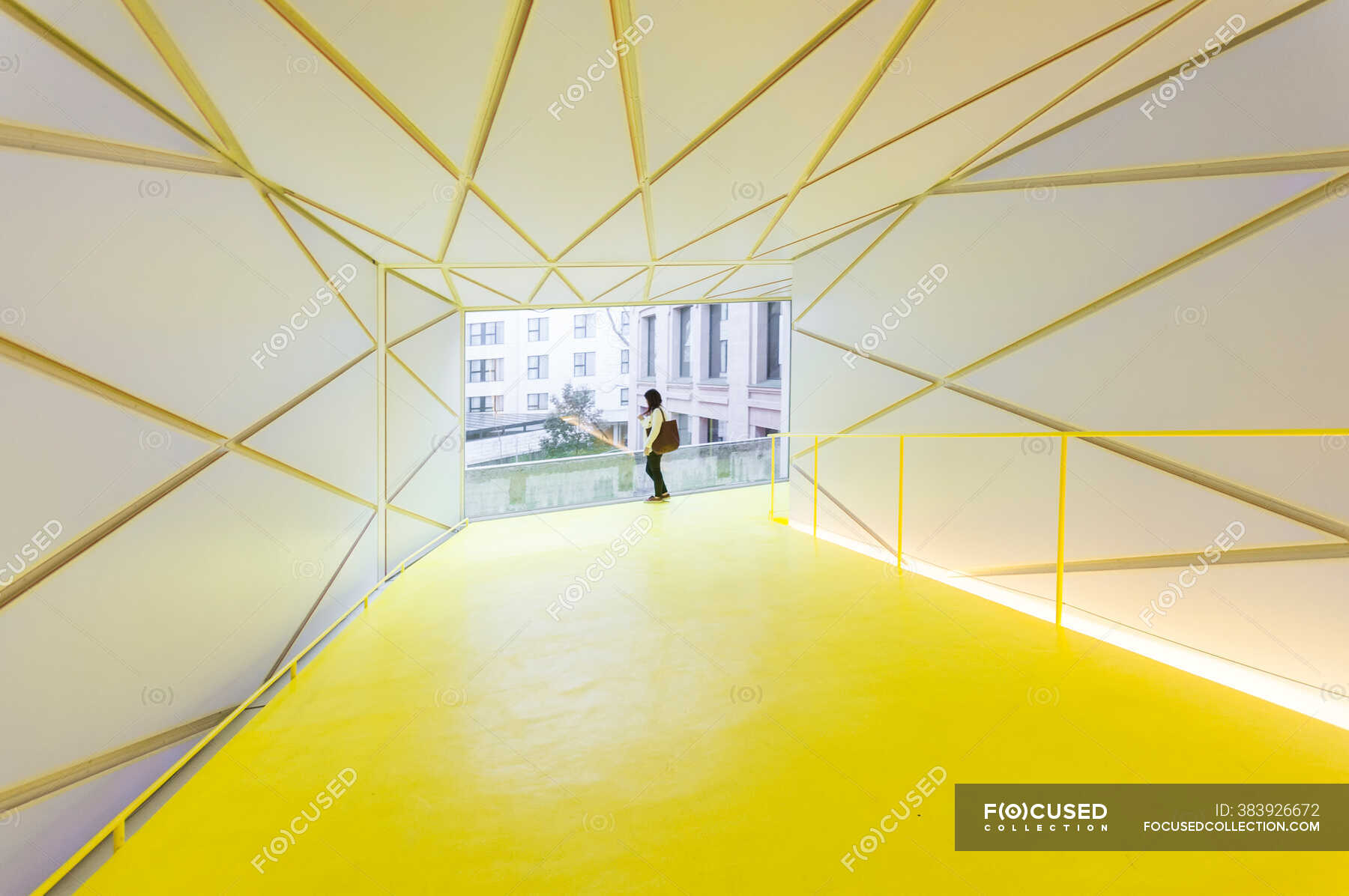 back-view-of-female-in-casual-wear-standing-near-railing-in-modern-ramp