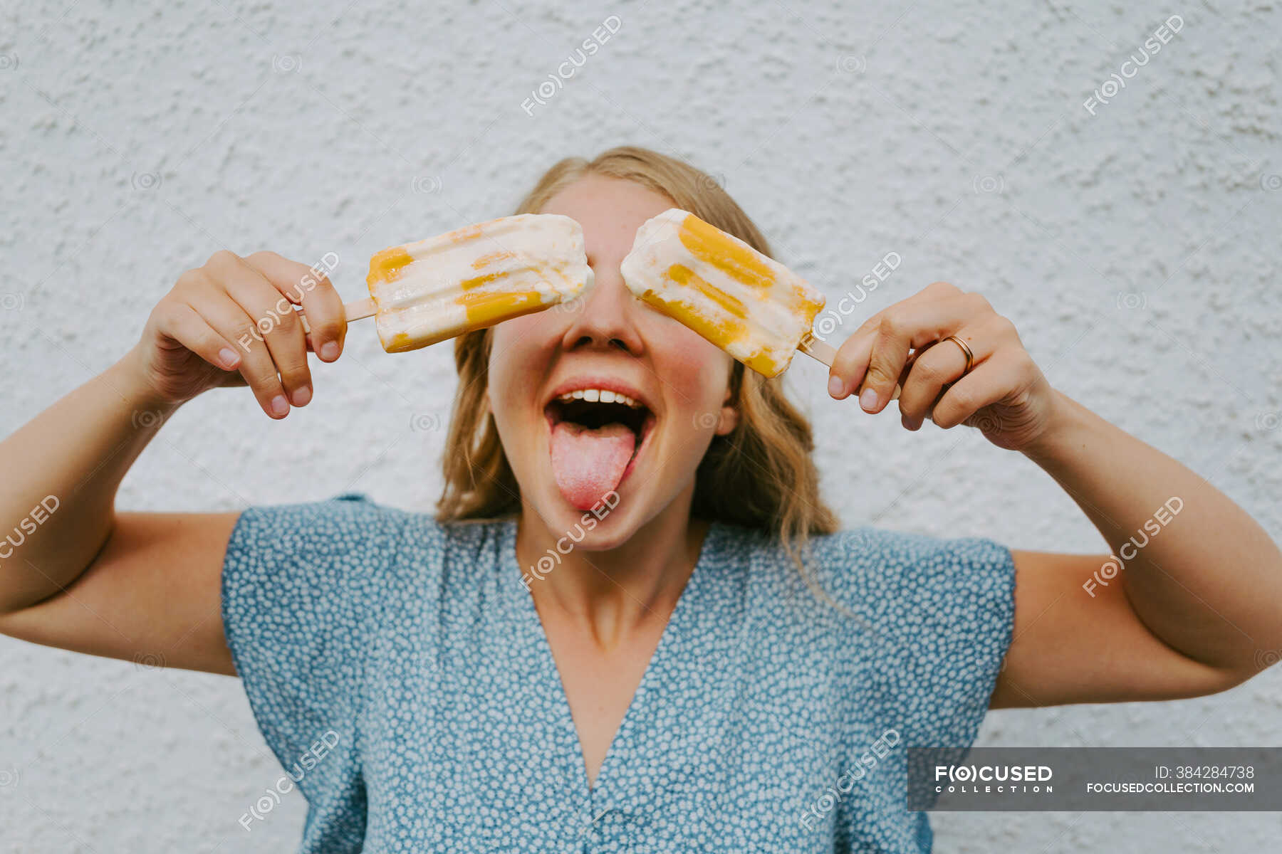 Female Making Funny Grimace With Tongue Out And Covering Eyes With Tasty Ice Lollies On Sticks 7817