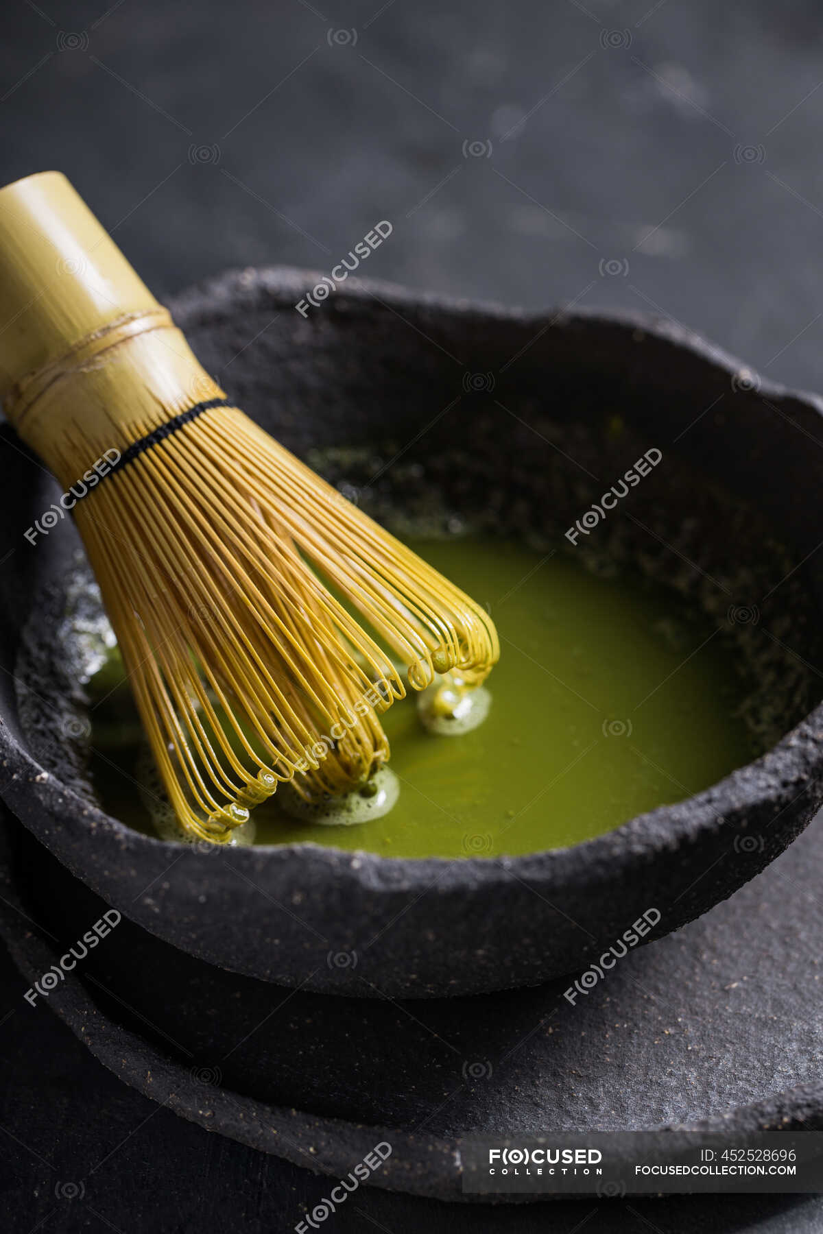 From above of traditional Japanese matcha with tea whisk in stone bowl