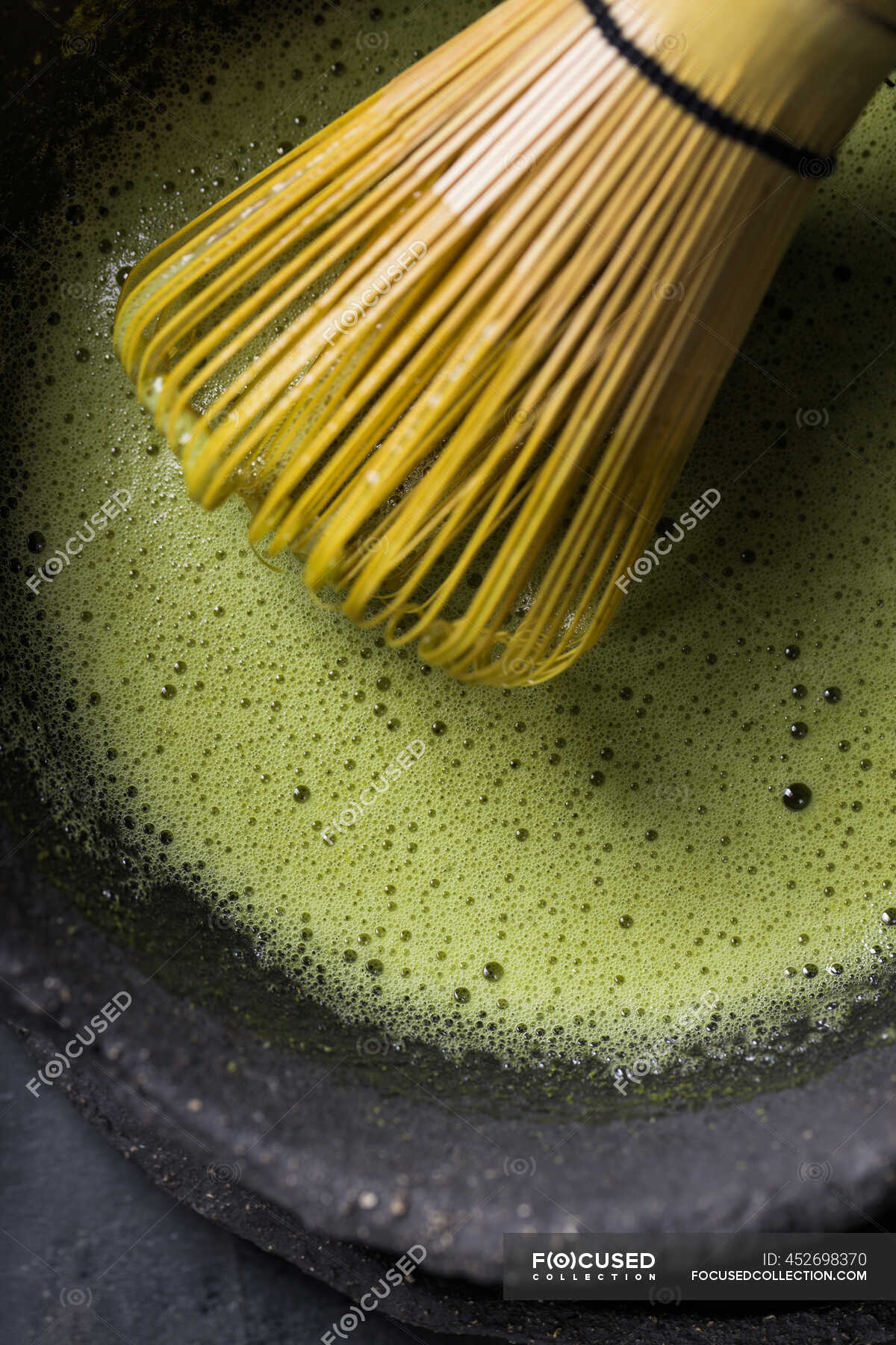 From above of traditional Japanese matcha with tea whisk in stone bowl