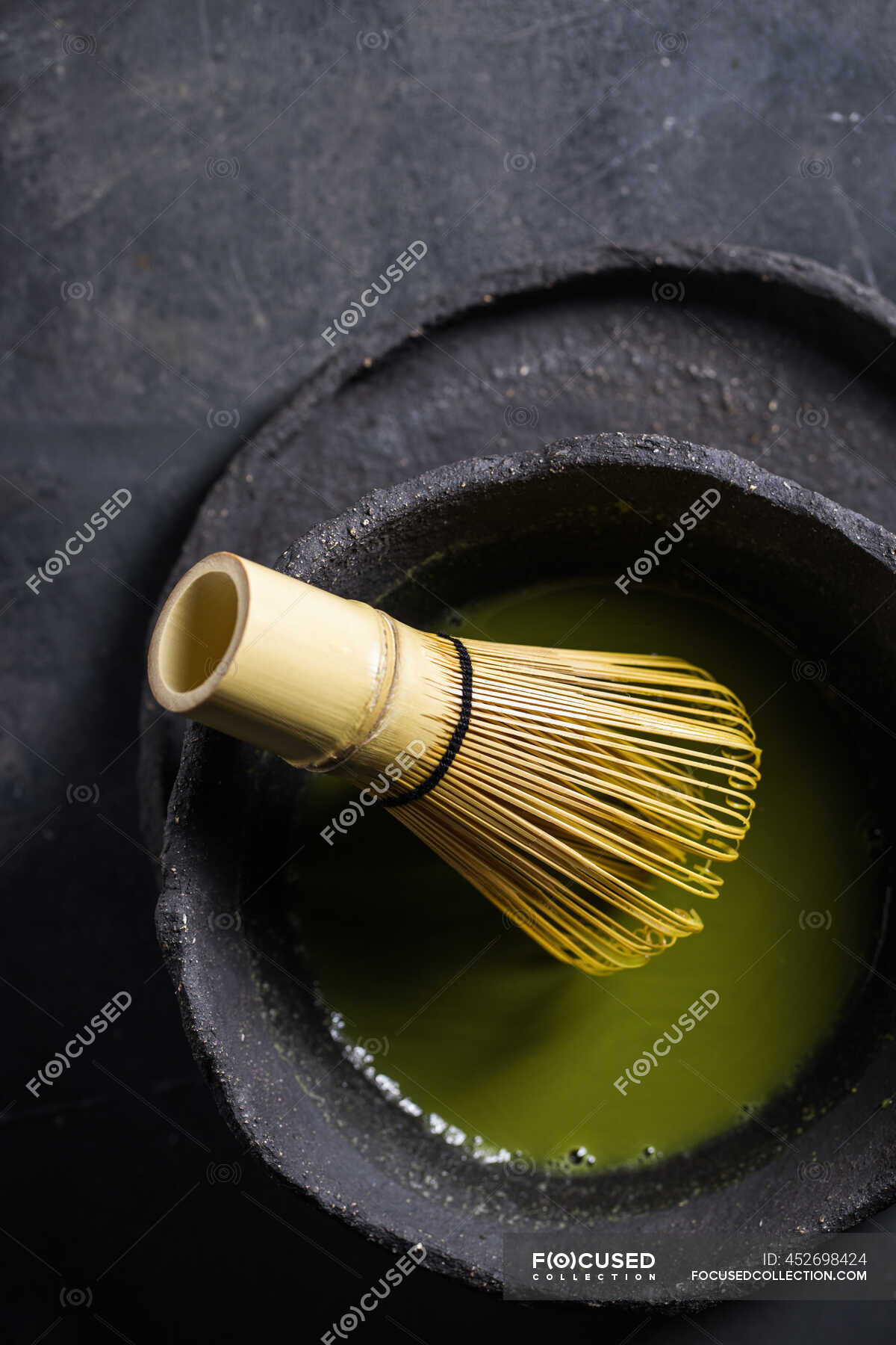 From above of traditional Japanese matcha with tea whisk in stone bowl