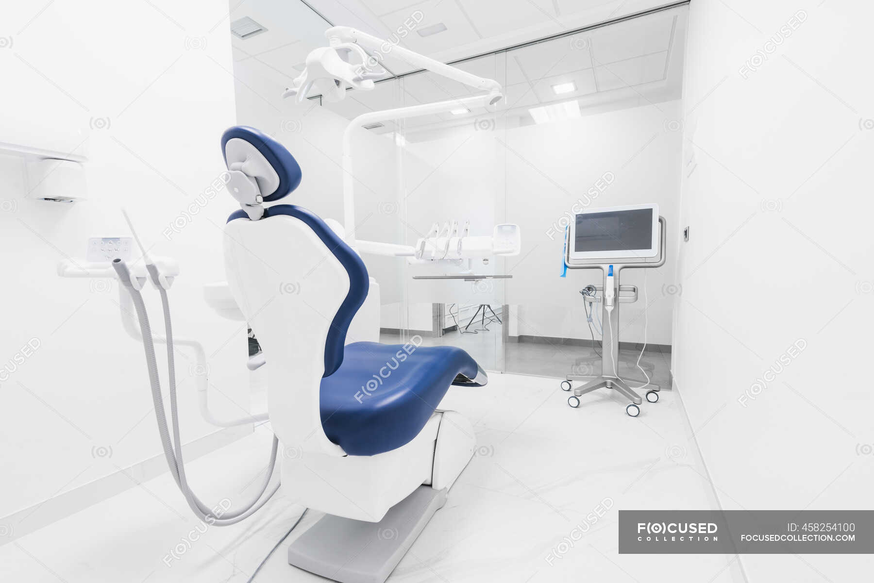 Interior of contemporary tidy dental clinic with blue chair and white  furniture equipped with modern dental machine and instruments — organize,  clean - Stock Photo | #458254100