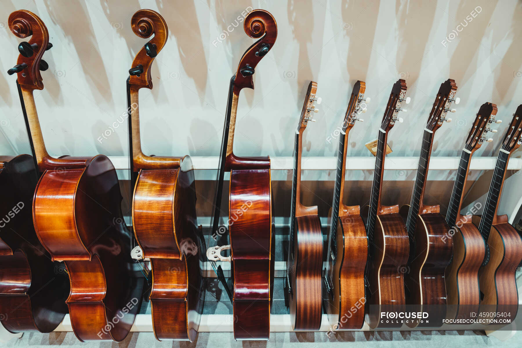 Guitars And Violins Hanging On Living Room Wall