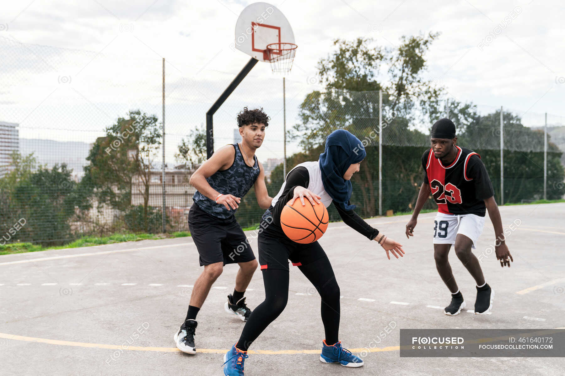 Grupo de pessoas multiétnicas jogando basquete na quadra