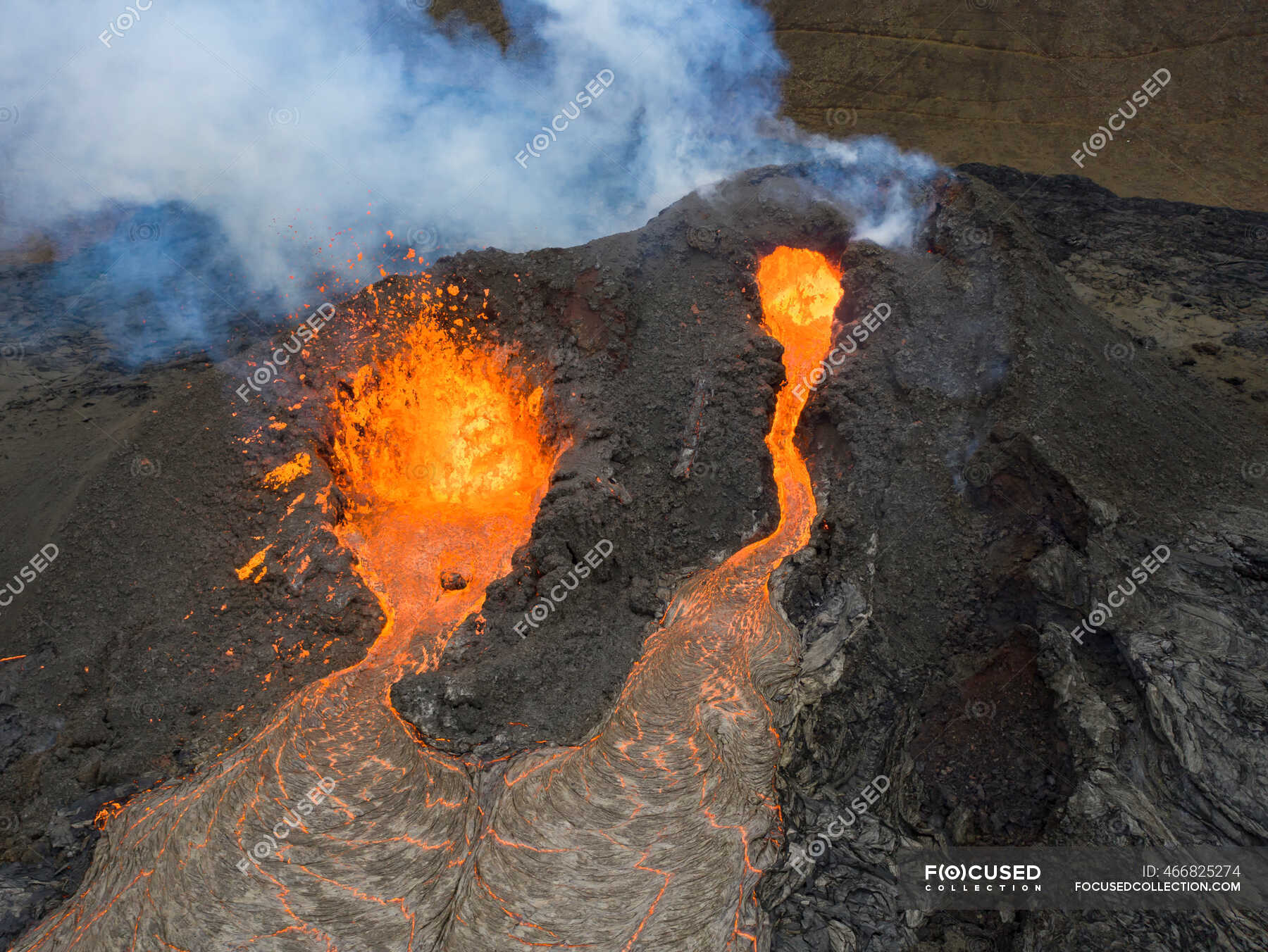 From above magma sparks out of the volcano hole and run like rivers of