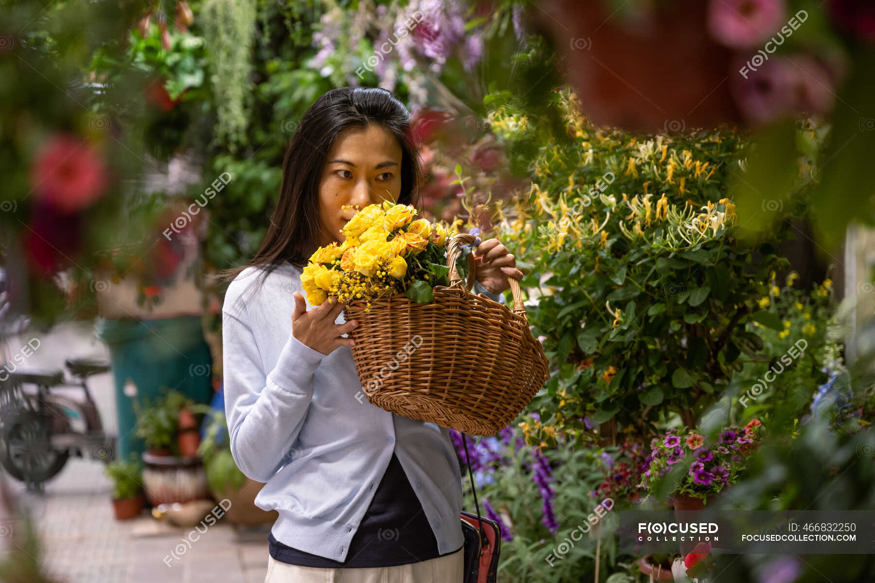 beautiful-asian-girl-buying-flowers-in-flower-shop-while-carrying-a