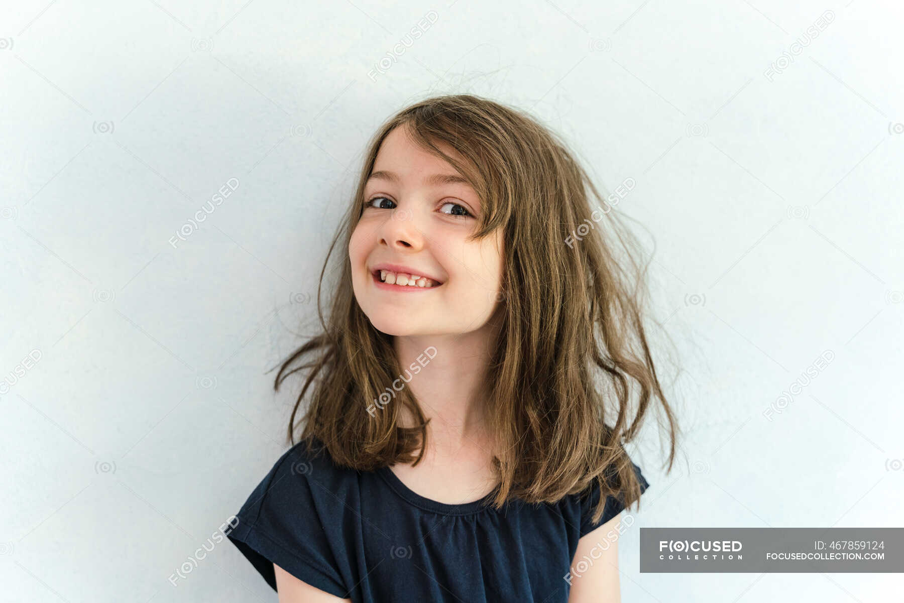 Cute little girl with messy hair dressed up as a witch and holding a broom  is standing in Halloween decorated living room looking at camera smiling  Stock Photo  Alamy