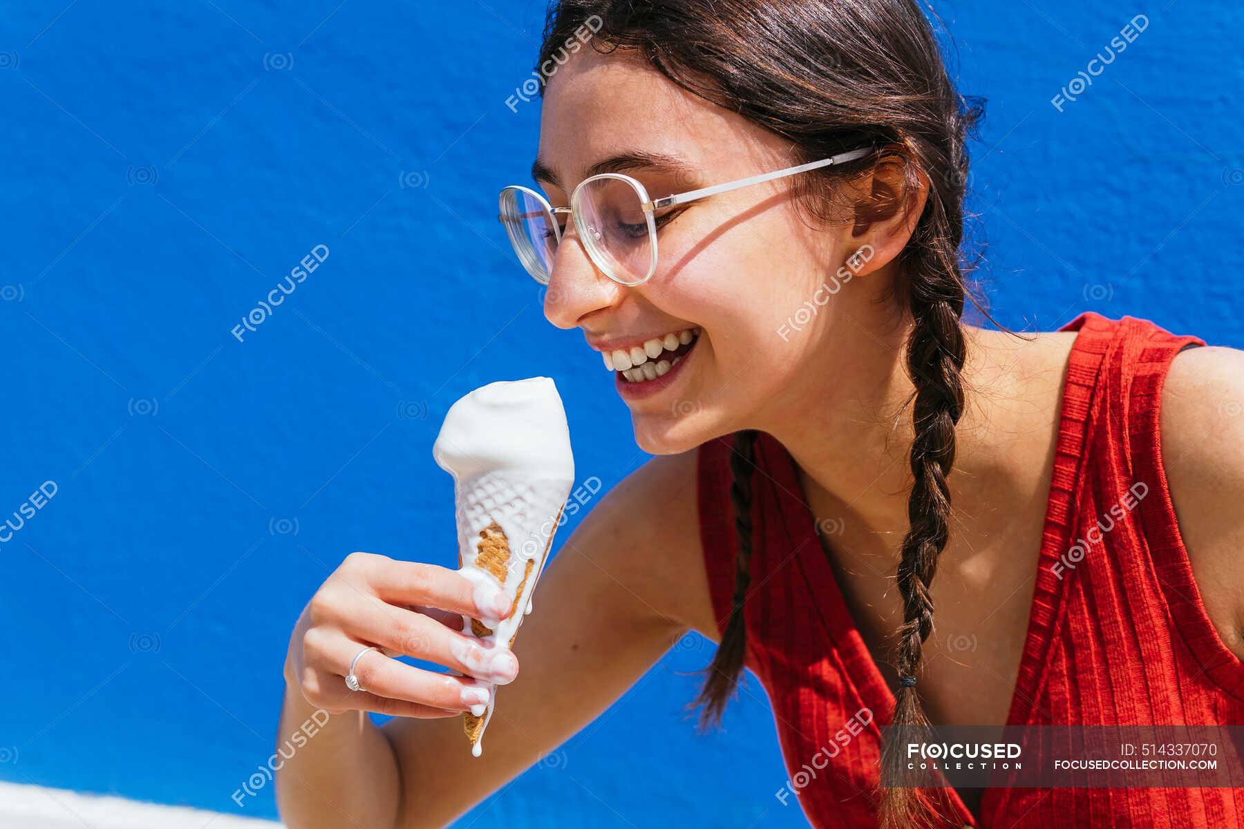 Delighted Female Eating Melting Ice Cream In Waffle Cone On Sunny Day