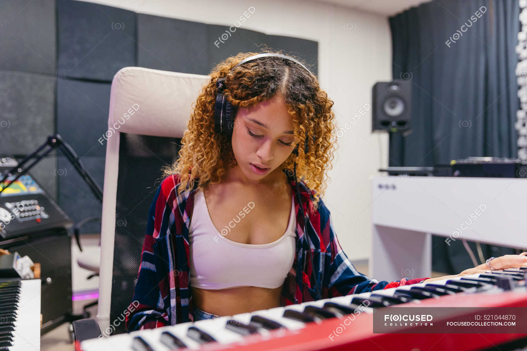 focus-african-american-female-singer-in-headset-playing-synthesizer