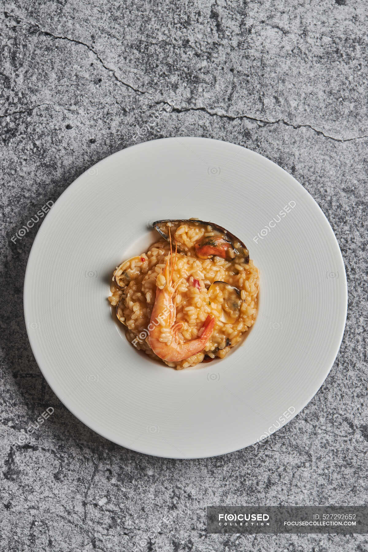 Desde arriba de apetitoso arroz con surtidos mariscos servidos en plato  sobre mesa en restaurante — tienda de delicatessen, Exquisito - Stock Photo  | #527292652