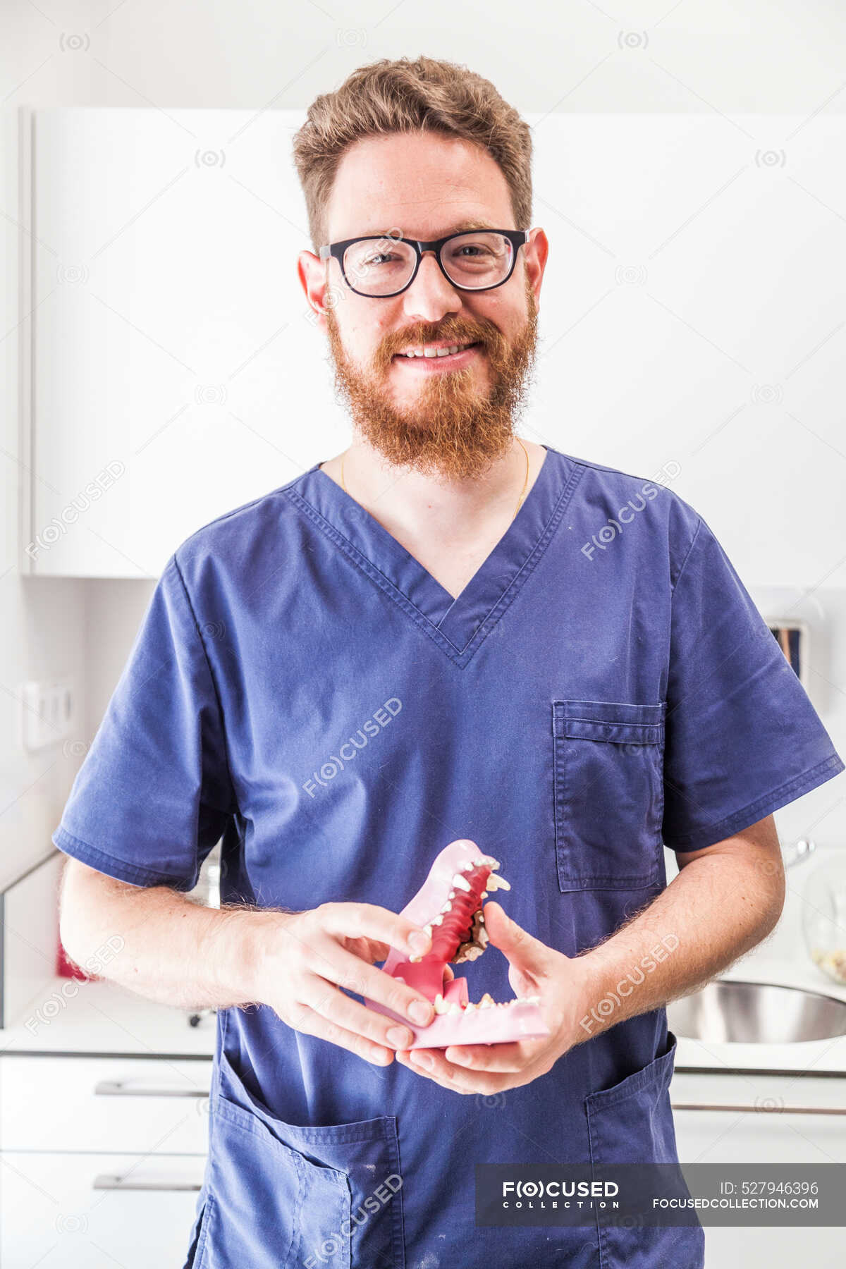 Positive bearded male in uniform and eyeglasses with artificial animal ...