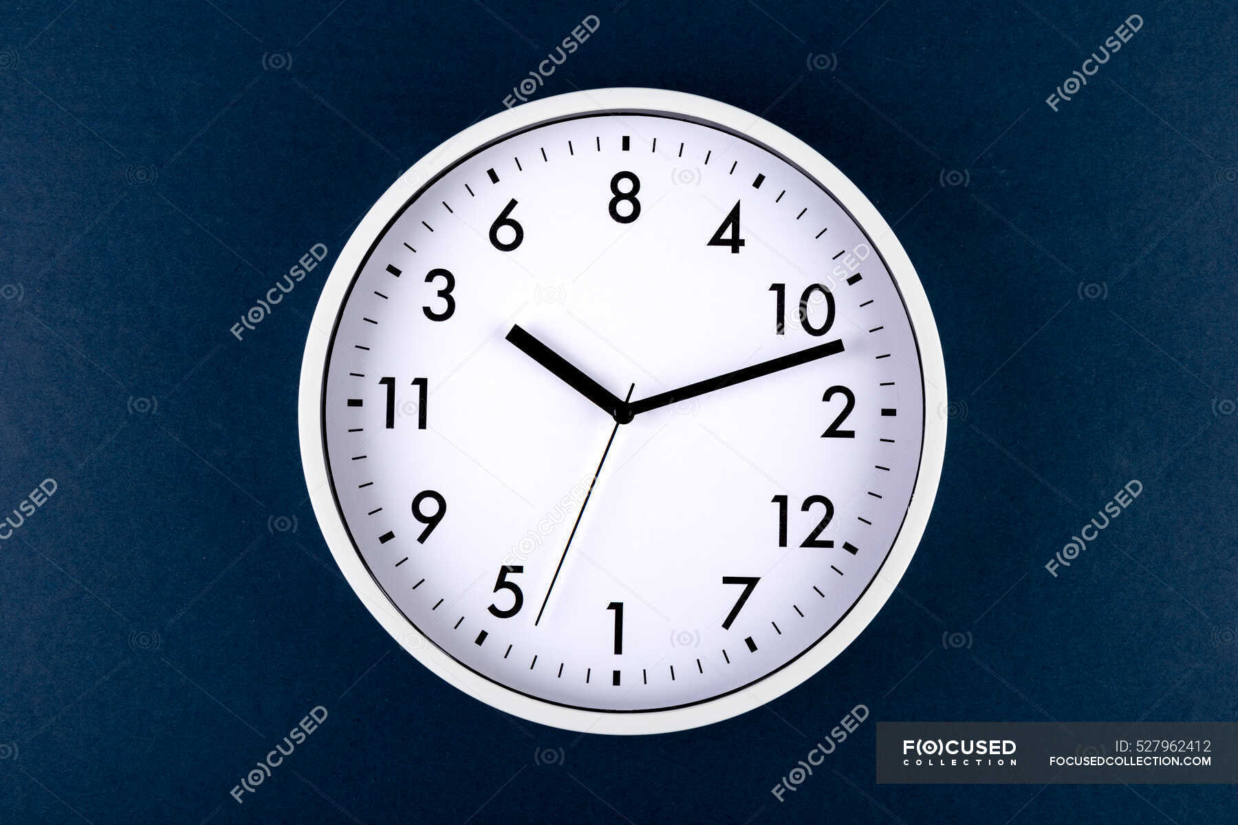 Round shaped minimalistic clock with numbers and arrows on colorful blue background — simple