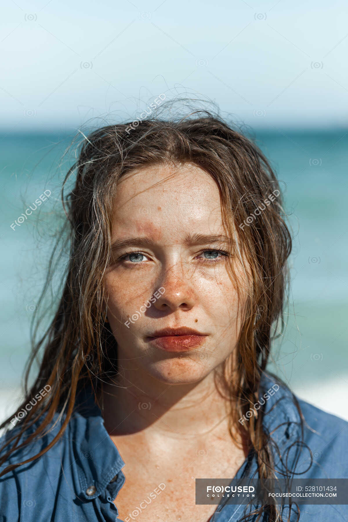 Female in wet shirt and with wet hair standing looking at camera on beach  near sea while enjoying summer day — relax, daylight - Stock Photo |  #528101434