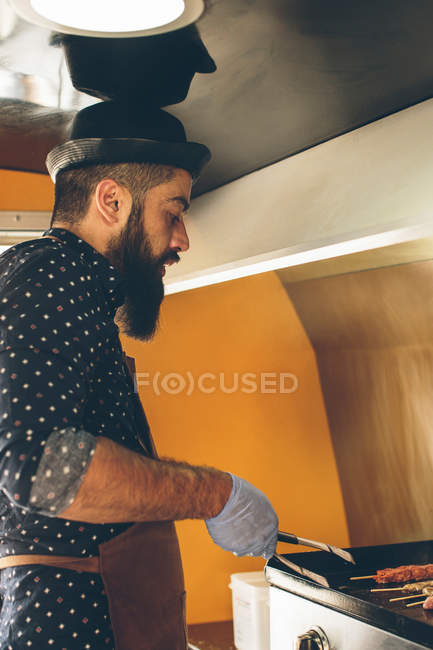 Hombre cocinar la preparación de alimentos en camión de alimentos - foto de stock