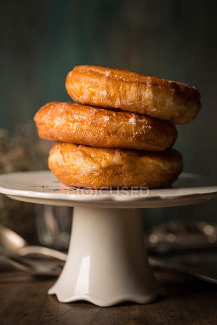 Вкусные пончики на стенде из белого фарфора — стоковое фото