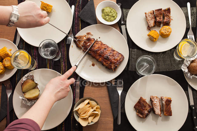 Table with grilled ribs, potatoes and corn — Stock Photo