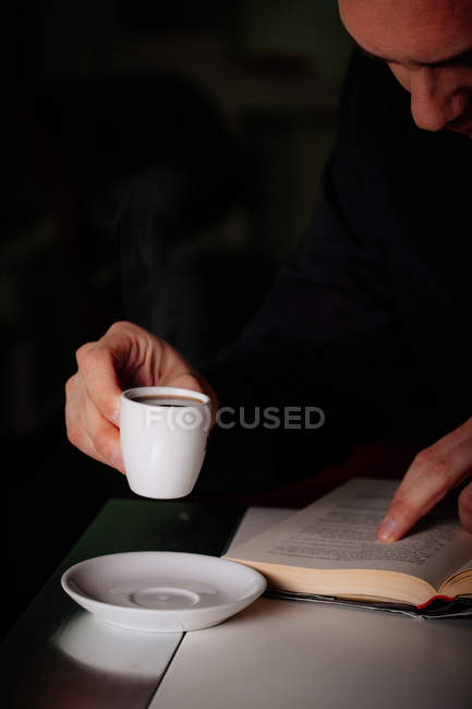 Homem lendo e desfrutando de café aromático — Fotografia de Stock