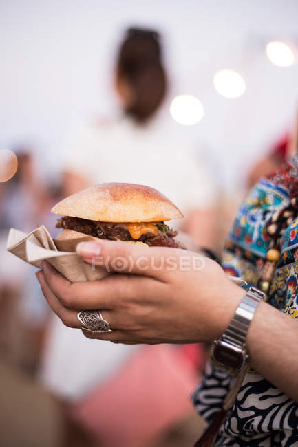 Hamburger in female hands — Stock Photo