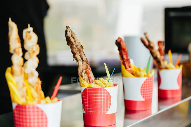 Grilled meat on sticks with fries — Stock Photo