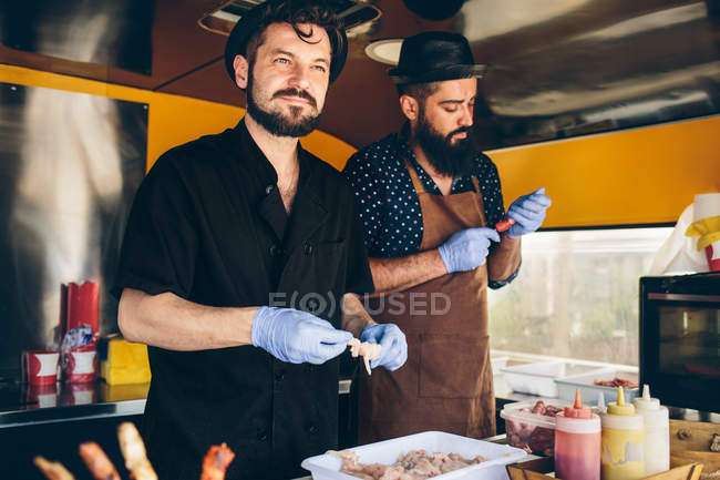 Los hombres cocineros preparación de alimentos - foto de stock