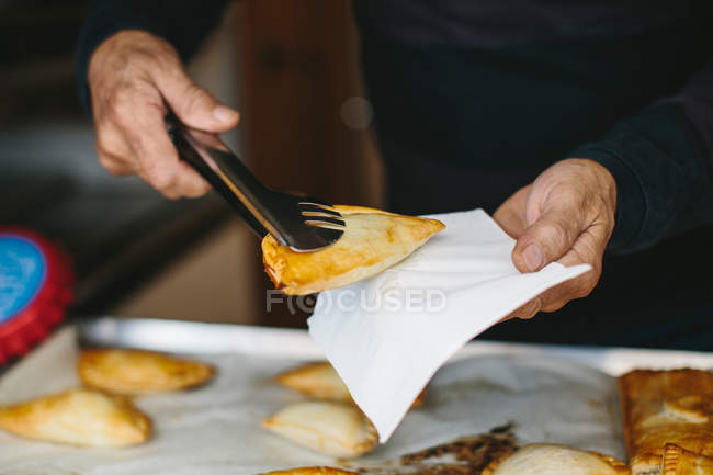Hands holding baked patty — Stock Photo